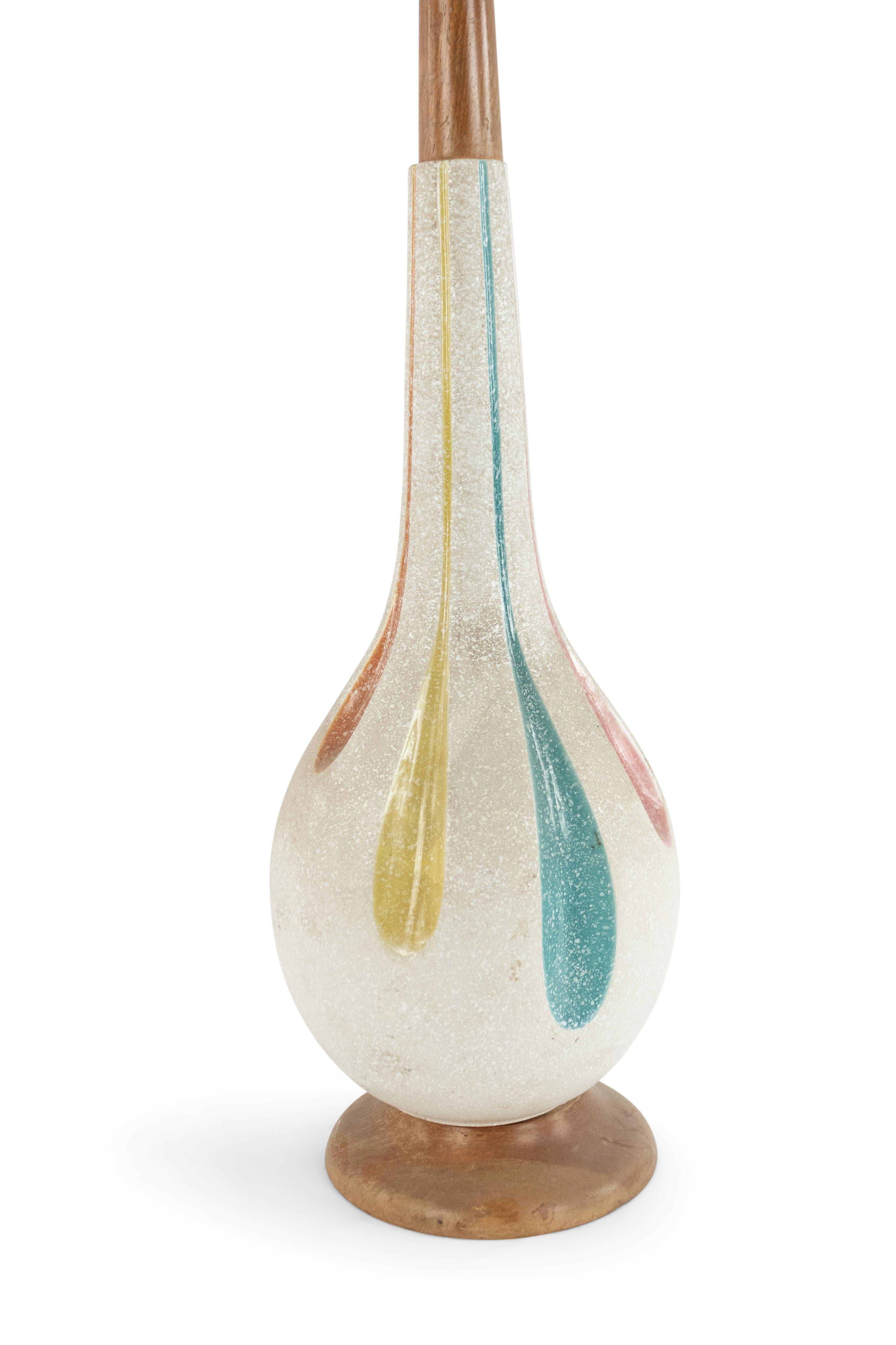 American midcentury beige porcelain table lamp with a tapered neck and stylized multicolored fluted design on a round wood base.