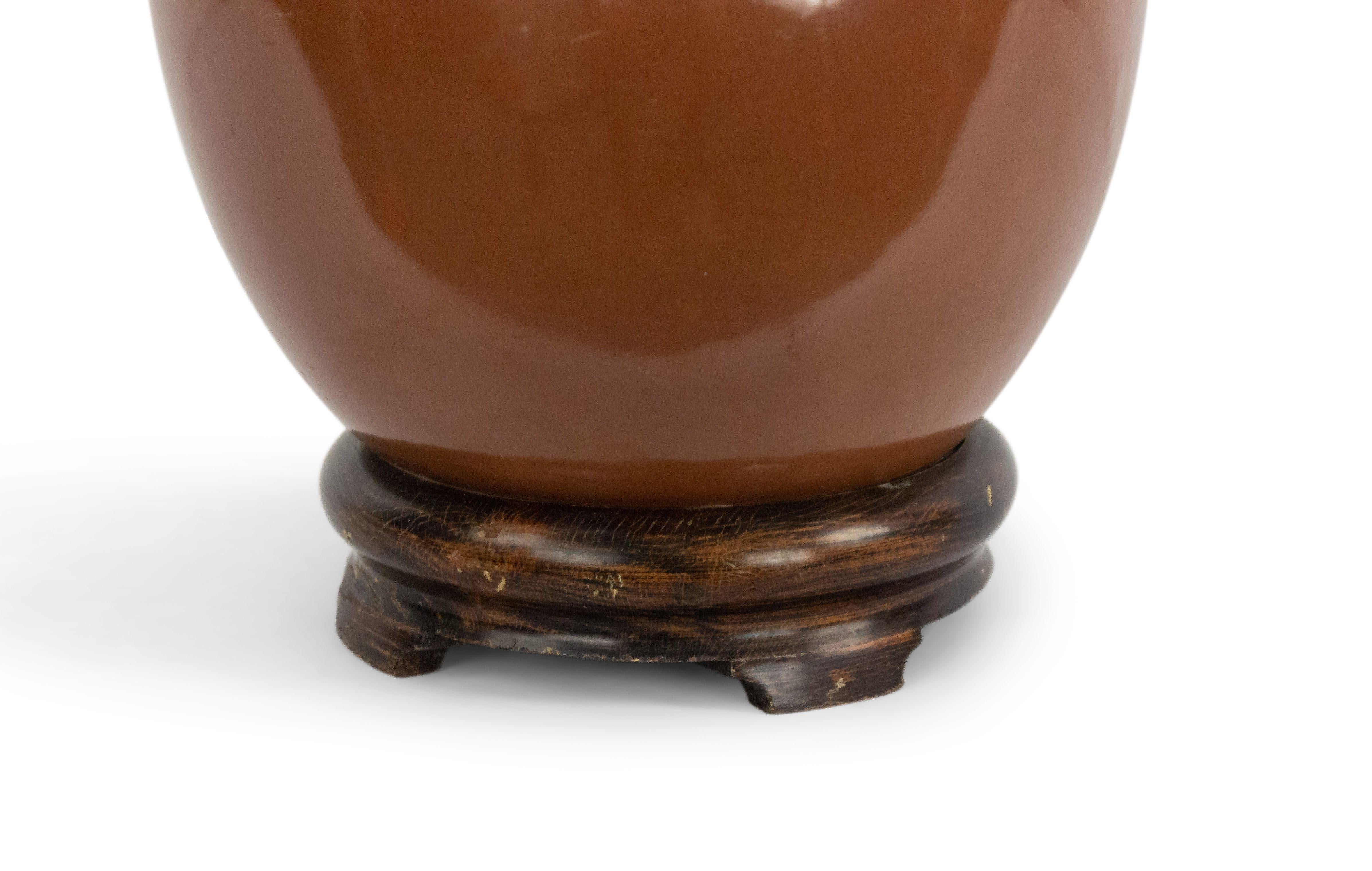 American mid-century brown porcelain 2 tier bulbous shaped round lamp with a round teak base.
     
