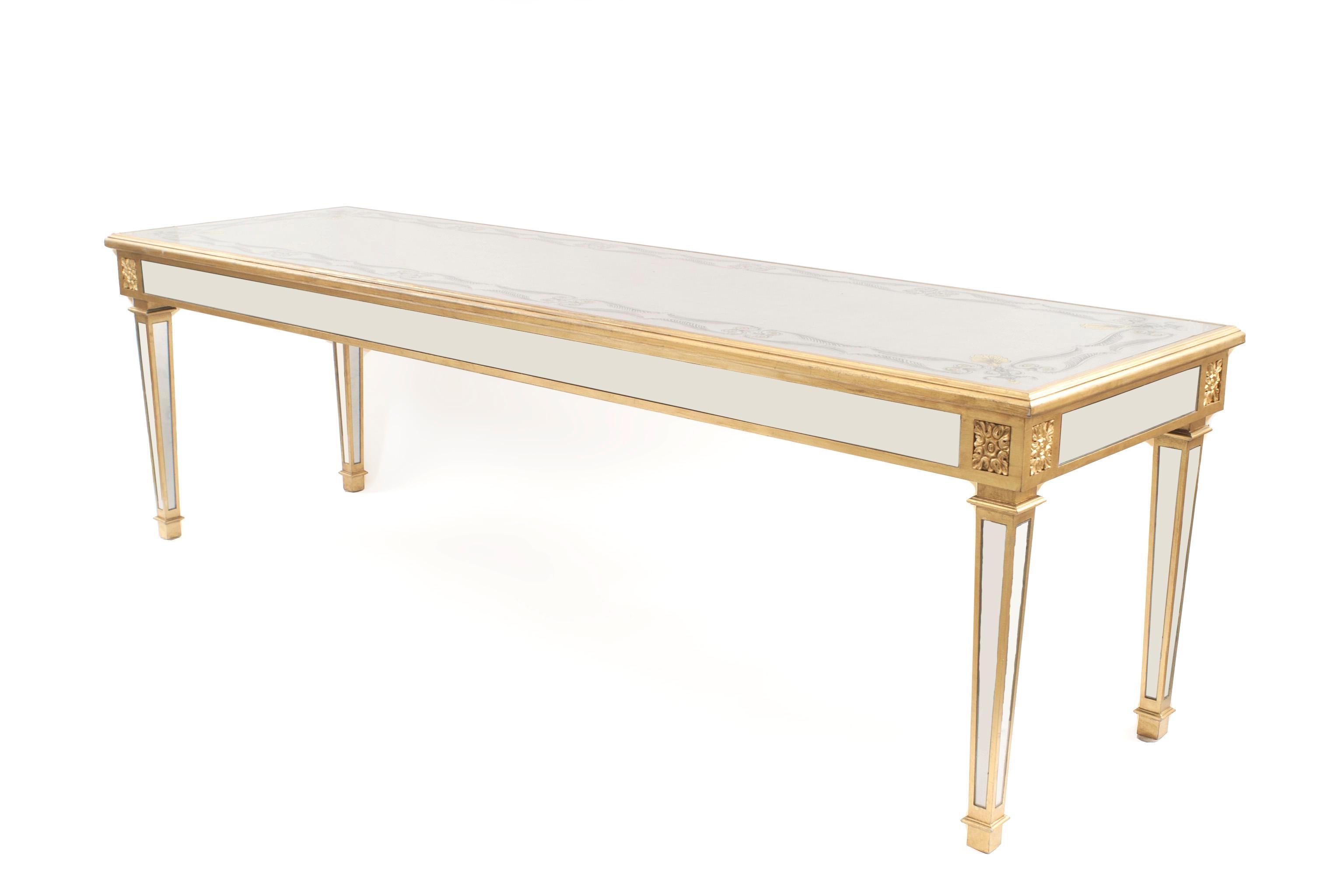 American Mid-Century console table having a silver leaf and eglomise decorated top inset in gold painted wood with a mirrored apron supported on square tapered mirrored legs
