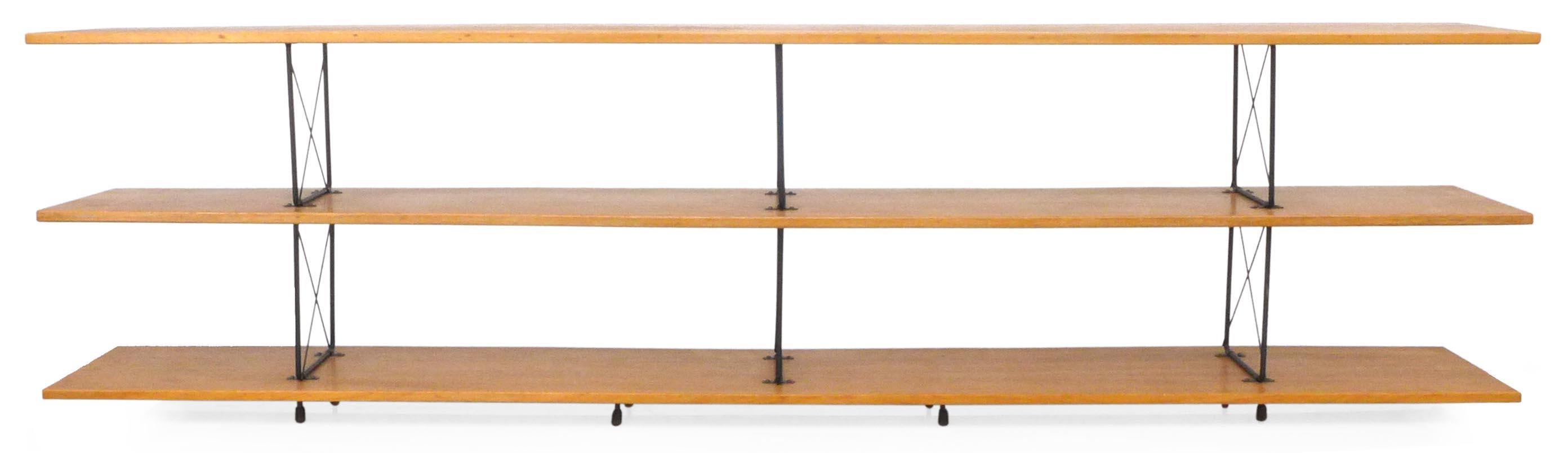A wonderful, American midcentury shelving unit in wood and iron. Assembled from a kit of D.I.Y. X-brace hardware and beautiful, mitered-edge, solid wood planks, a clearly Eames/McCobb inspired design quite well assembled. Retains original