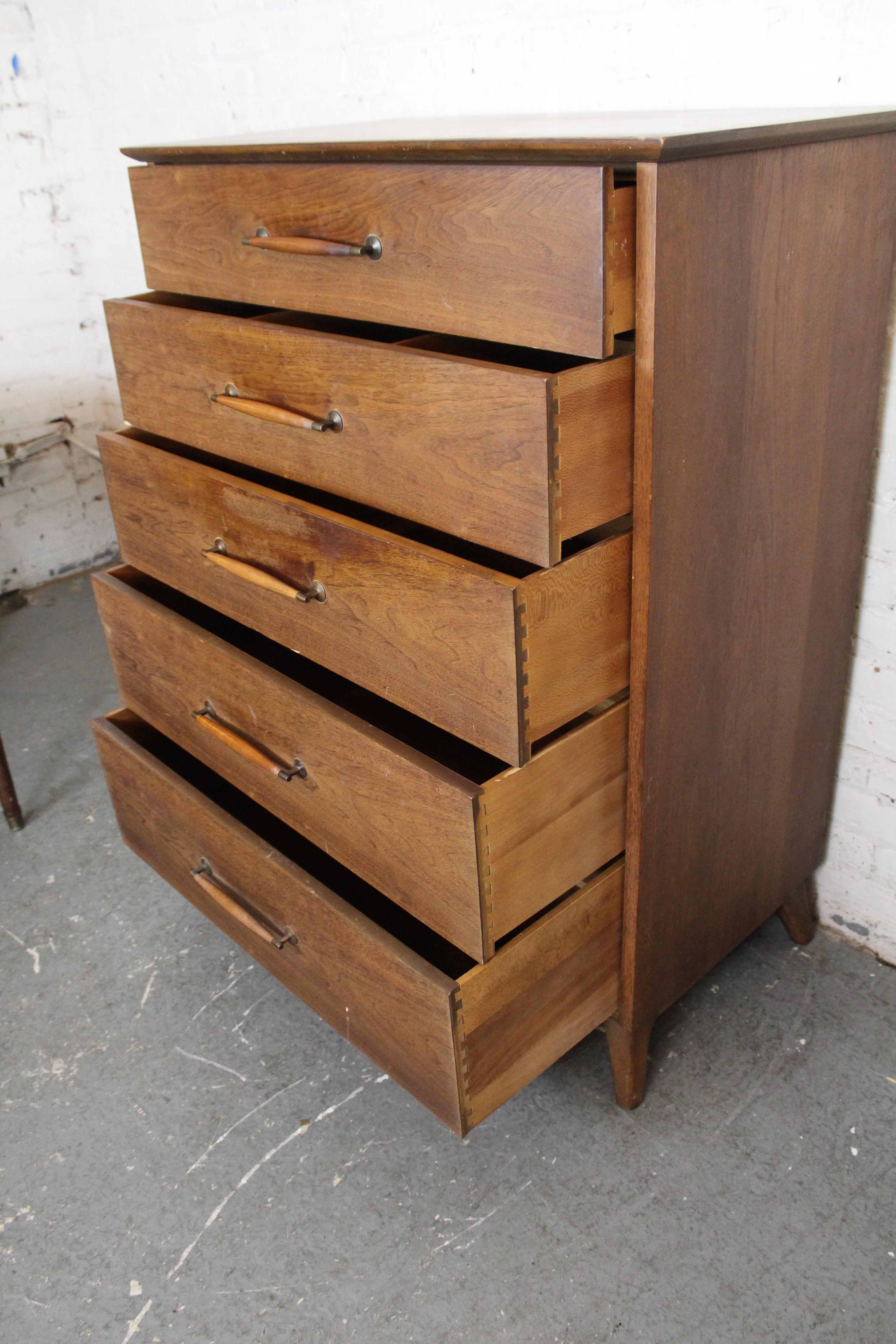 Make a big splash in any decor scheme with this beautiful mid-century American highboy dresser from the esteemed Heritage-Henredon Furniture factory of Morganton, North Carolina. Blending the aesthetics of traditional American Shaker furniture with