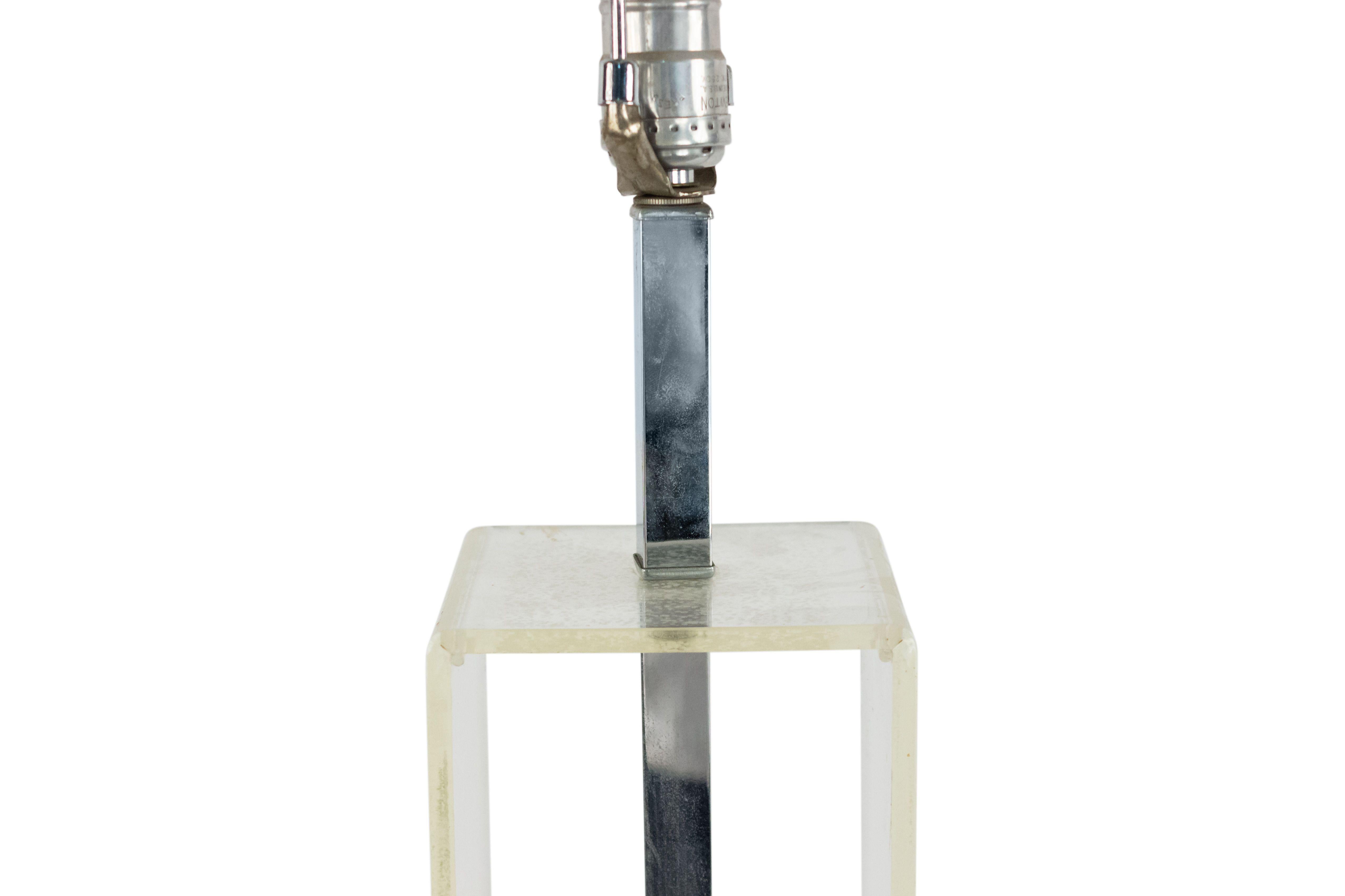 American midcentury table lamp with a Lucite open rectangle over a chrome cube base with a concave top.