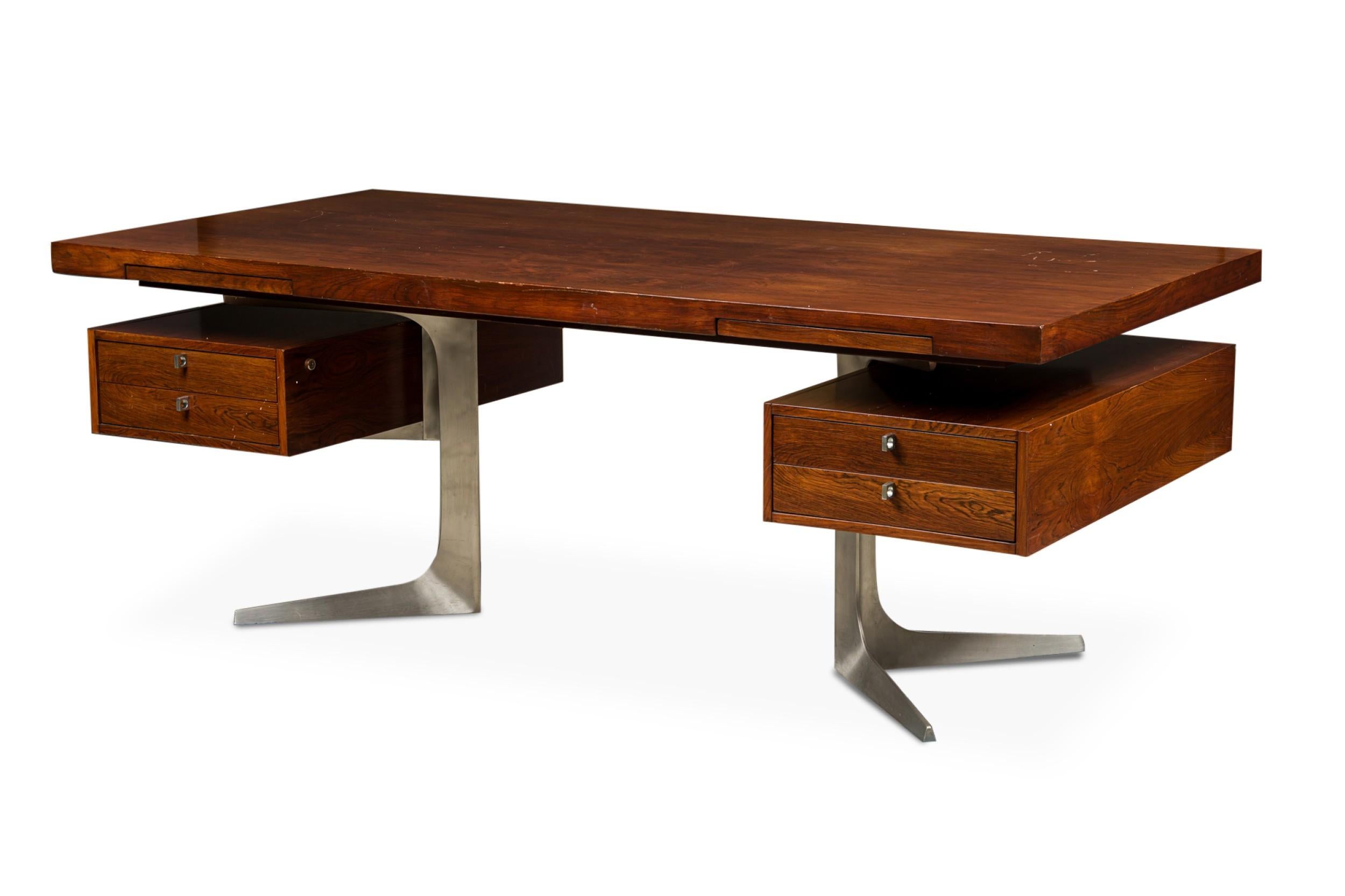 Mid-Century rosewood large executive desk with pull out shelves on top resting on 2 drawer units over a Pair of aluminum pedestal bases (HERBERT HIRCHE-Christian HolzÃ¤pfel KG)
Germany, 1967) (matching office sideboard NWL7017)

Top suface has