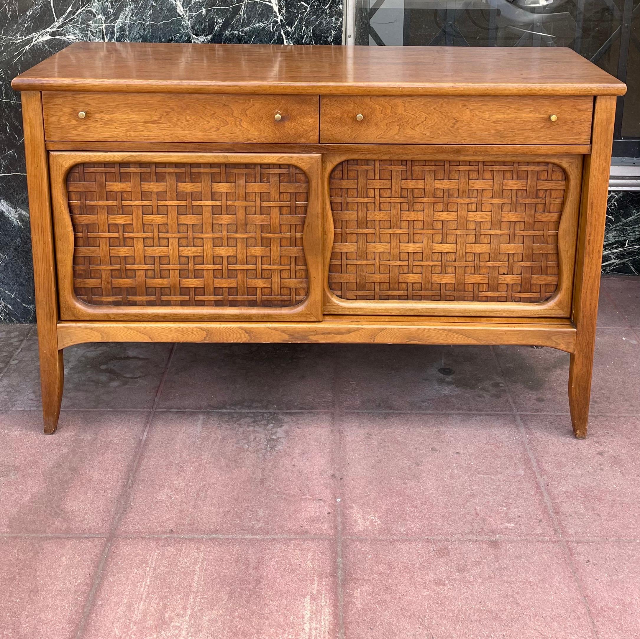 Beautiful classic atomic age design, American walnut credenza with woven wood front doors all in its original finish some light marks, great size good condition we have oiled and cleaned the piece but its sold as-is condition.