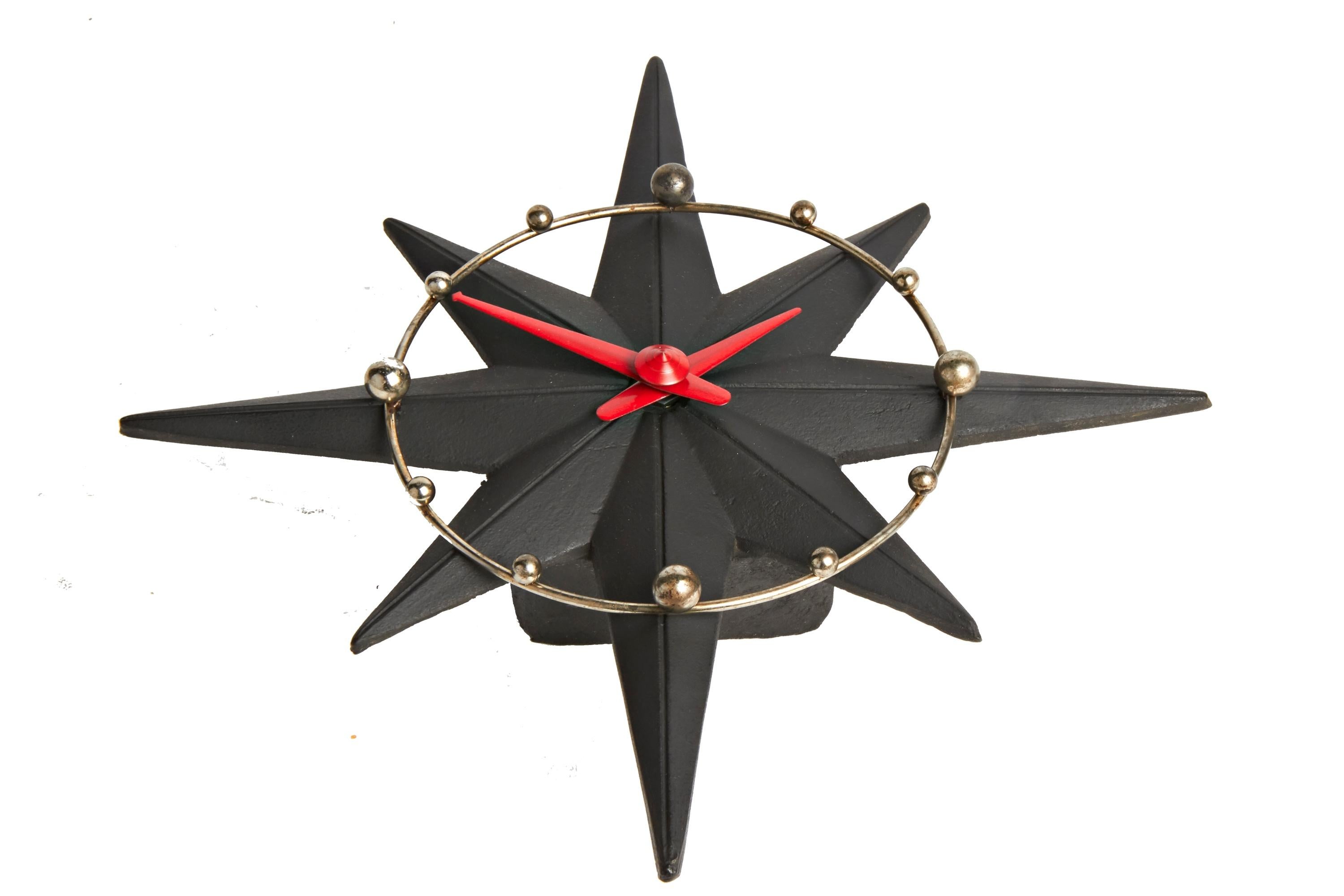 This beautifully designed American electric wall clock is the Model 106, Star-Flyte by Haddon Products of Chicago, Illinois. Its black painted, 8-point, compass star shaped body holds a chrome chapter ring that features chrome plated spherical