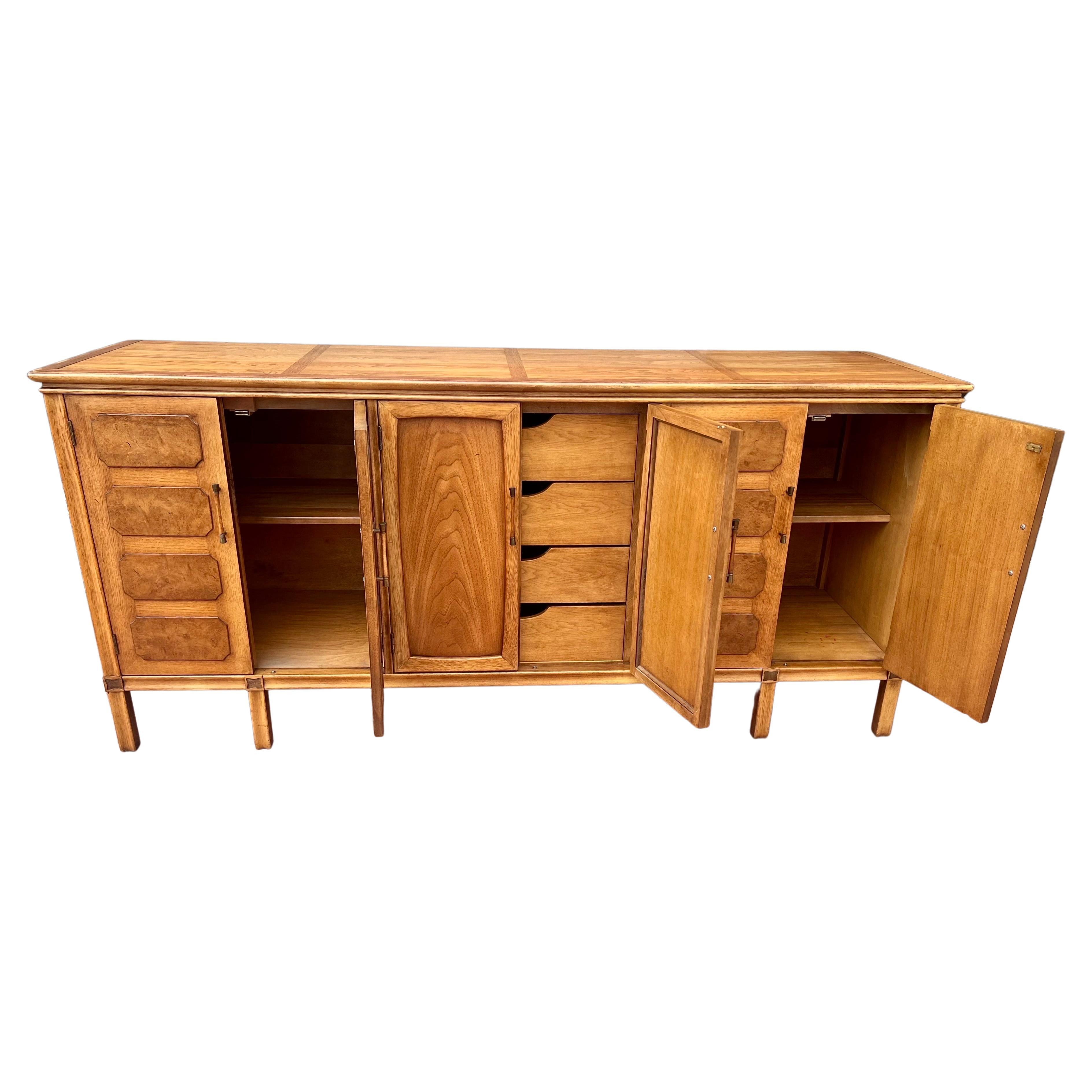 Elegant beautiful credenza by Thomasville part of the Timeline, circa 1960's nice brass accents with olive burl wood and a pecan/walnut finish we have oiled and cleaned the piece very nice original finish and condition.beautiful handles lots of