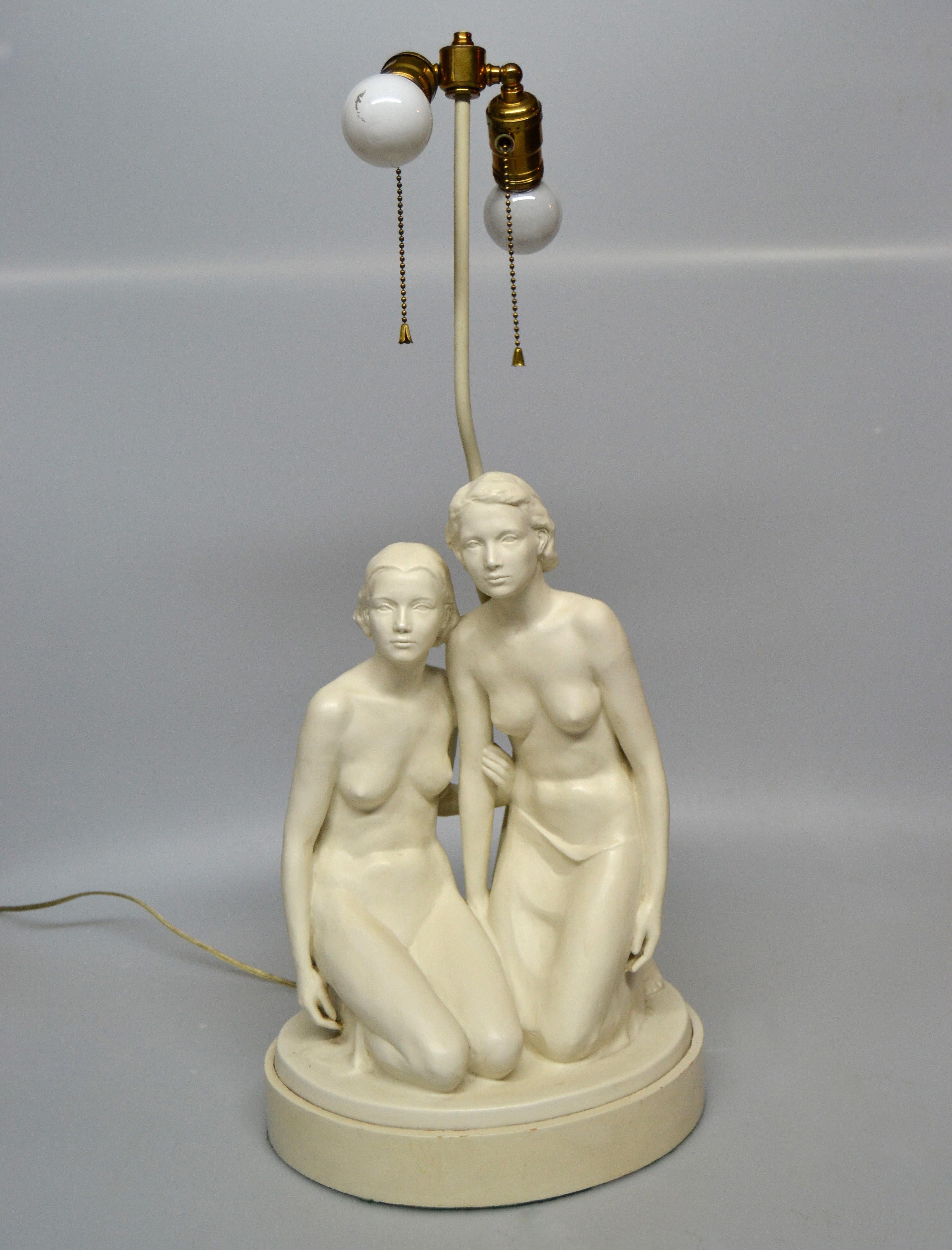 Lampe de table en plâtre de style moderne du milieu du siècle, avec deux femmes nues sculptées à la main et montée sur une base en métal.
Les porte-lampes sont en laiton avec des douilles à double faisceau et des cordons de tirage.
Peut supporter
