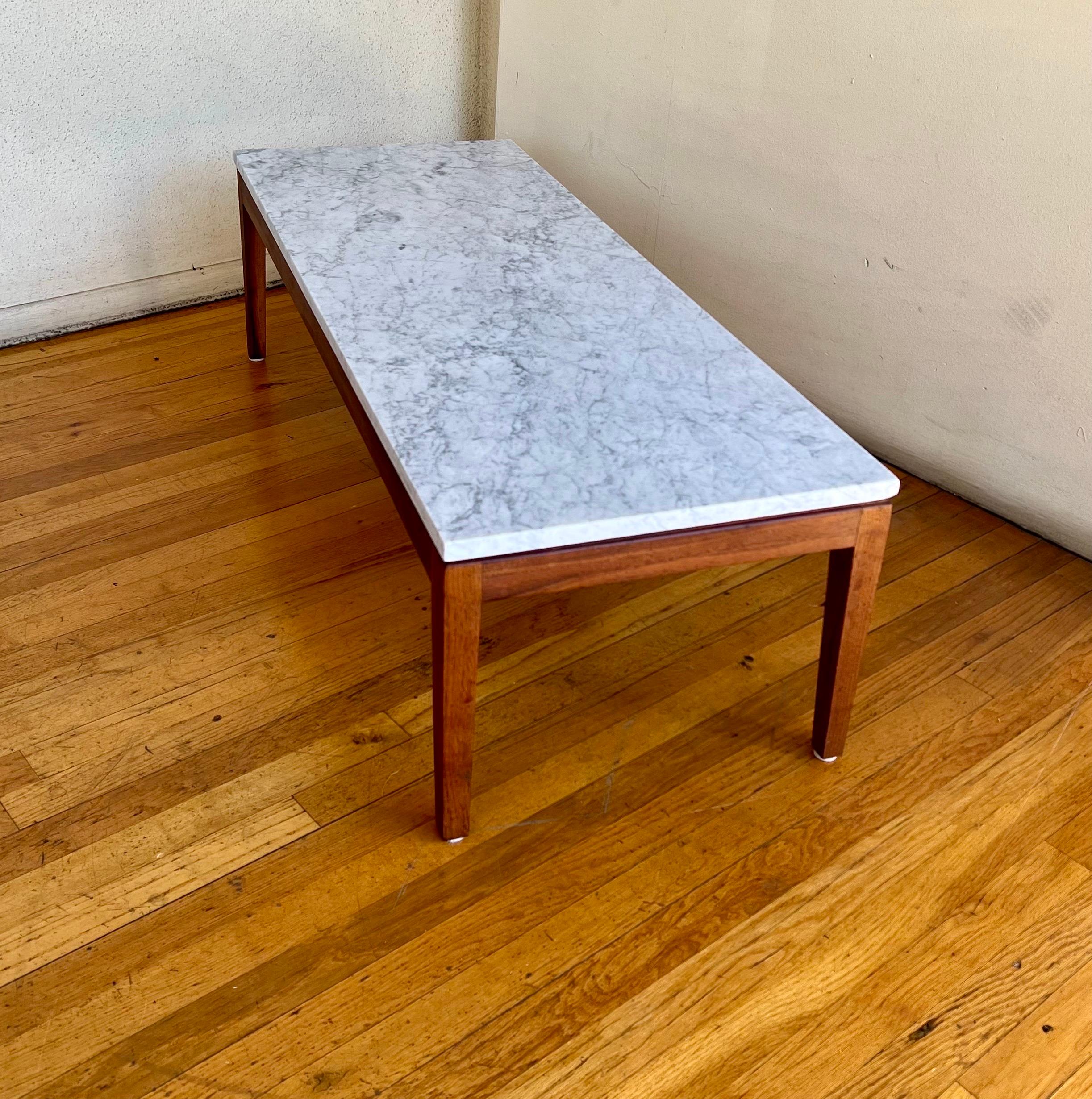 Simple elegant solid and sturdy freshly refinished base, in walnut with freshly polished Italian marble in great condition, on this American classic coffee table.