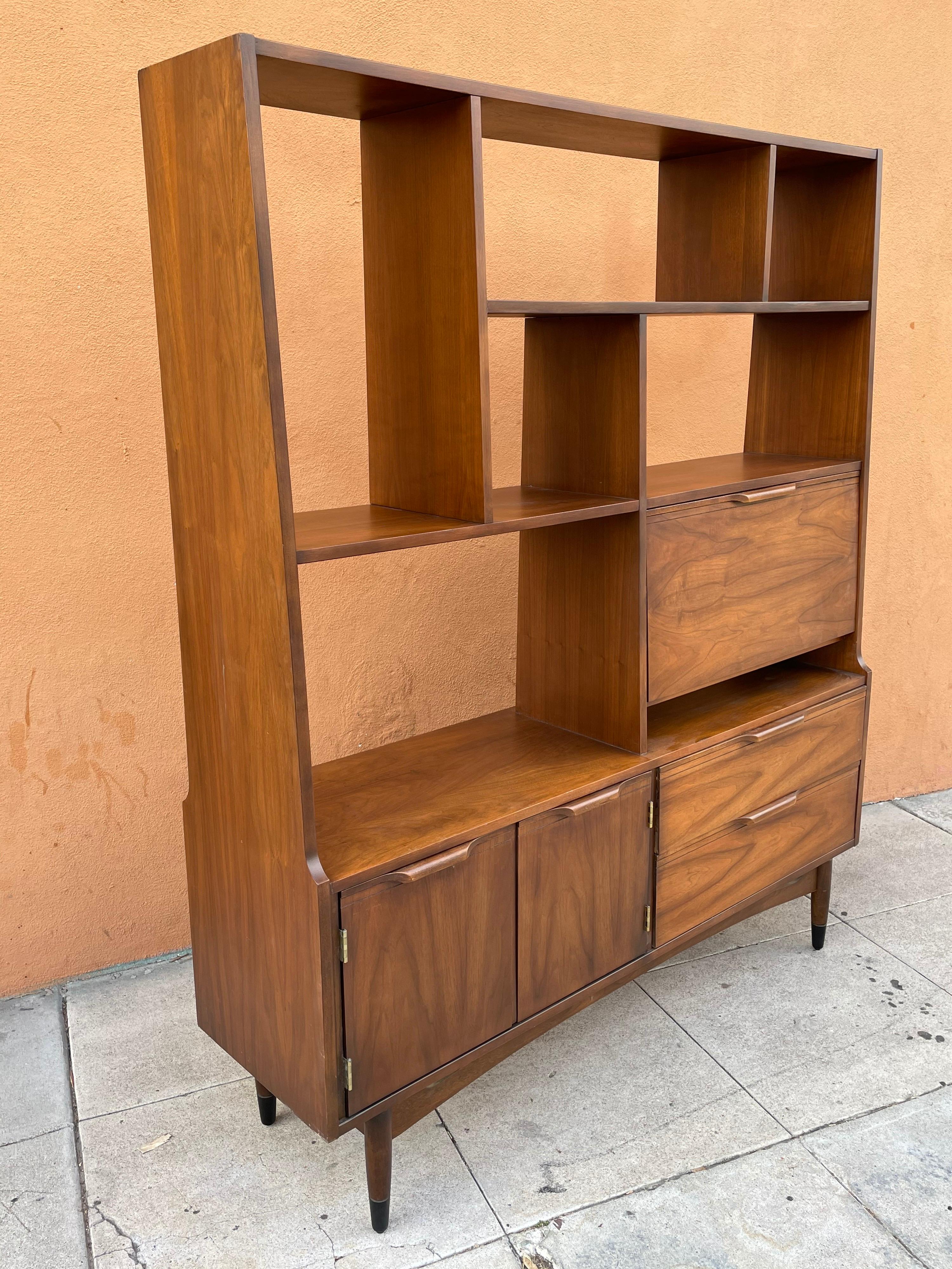 Beautiful and rare in walnut finish, American room divider/bookcase with desk cabinet and 2 drawers double door storage. Freshly refinished circa 1950s nice tapered legs with black lacquer tips. and refinished in the back.