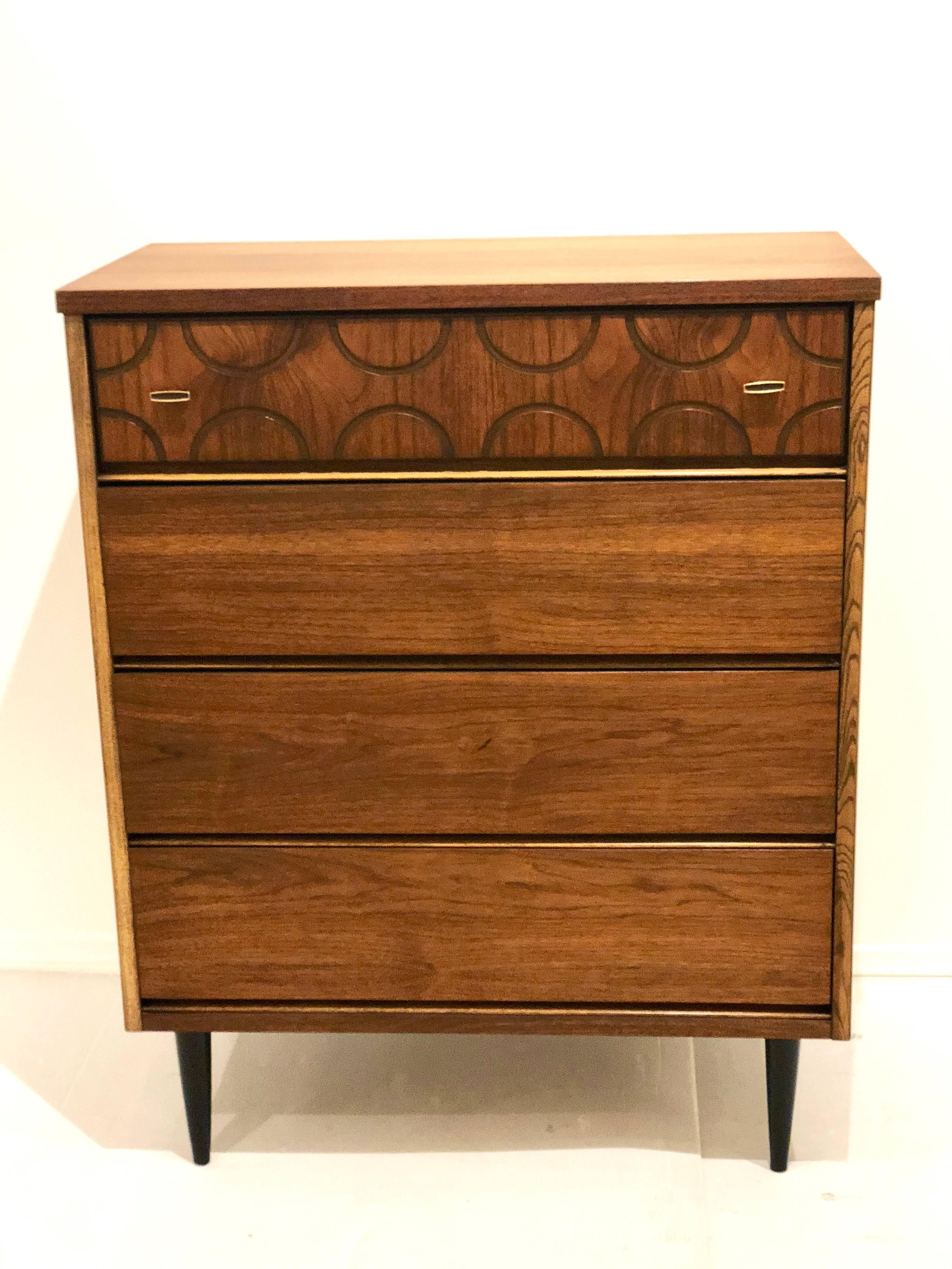 A beautiful chest of drawers, circa 1950s, American walnut with brass pulls and black lacquer legs and incredible top drawer design. Freshly refinished and in great condition drawers work great and its solid and sturdy nice and clean and a wonderful