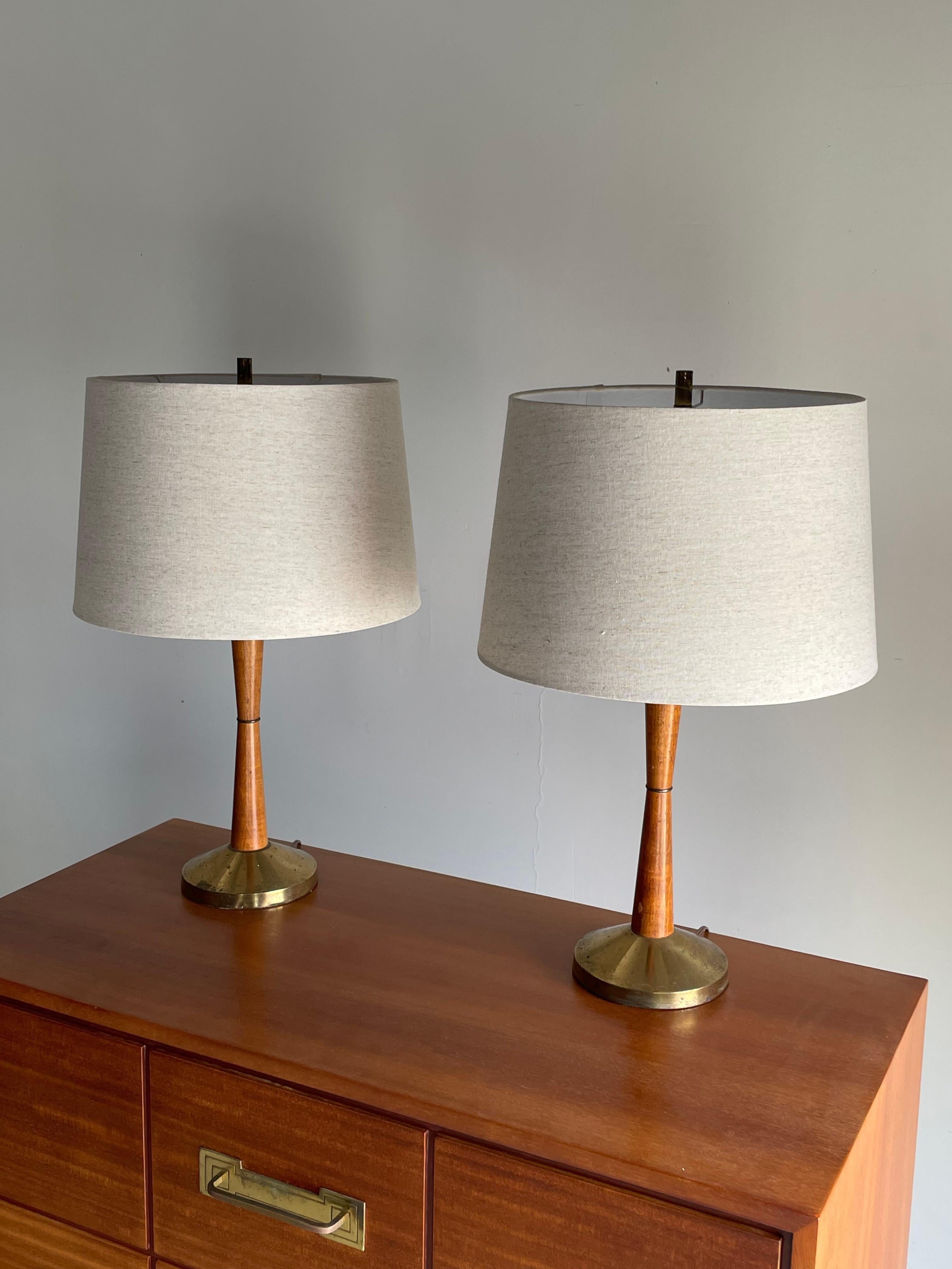 Iconic Mid-Century Modern table lamps. Features a brass base and walnut hour glass shape. Other lamp makers from the period include Modeline, Yasha Heifetz, and Paul McCobb.

Overall:
24” tall
15” wide

14” tall to top of wood
6” base.