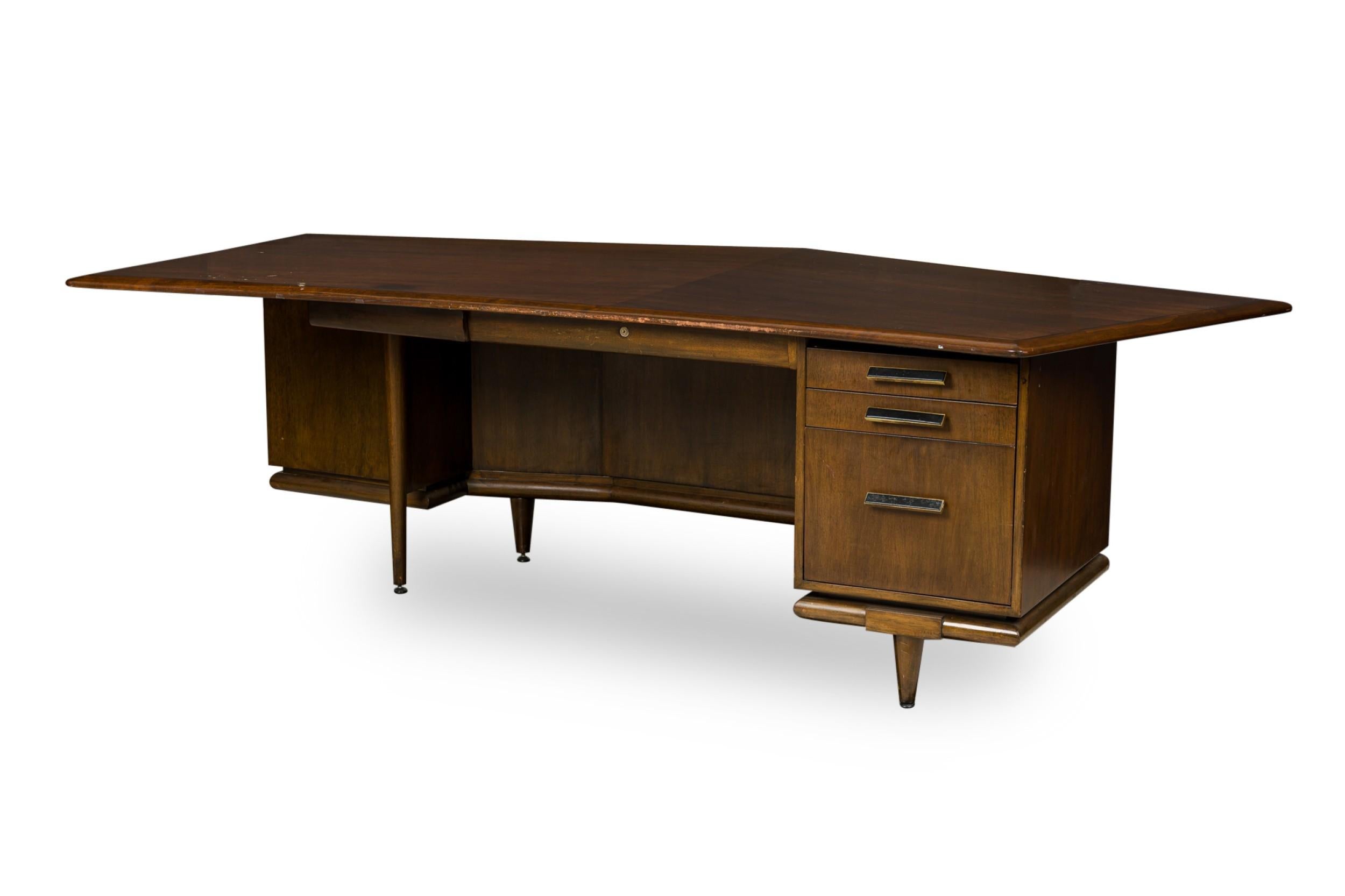 American Mid-Century walnut executive desk having an angular top with a centerdrawer and 3 stacked side drawers designed with a vanity front panel (custom made by MONTEVERDI YOUNG)
