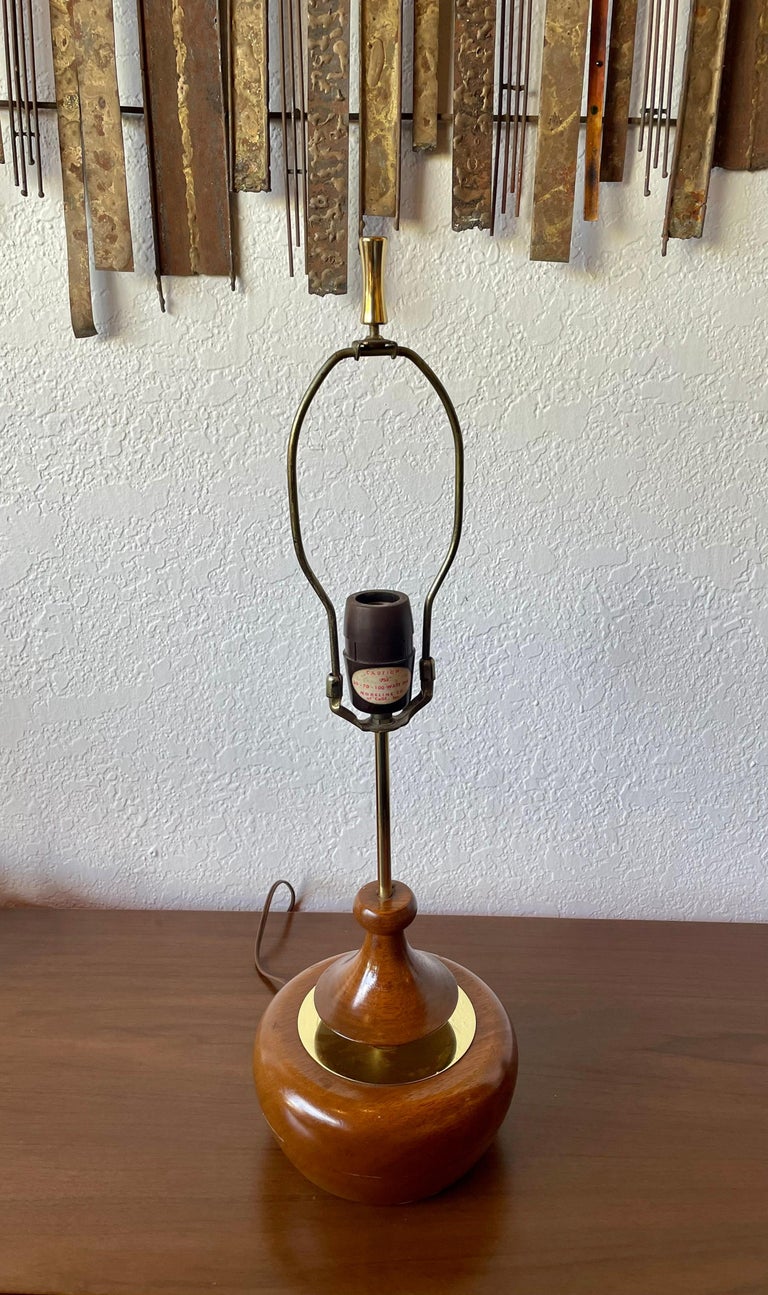 An unusual pair of table lamps by Modeline of California. Lamps are in excellent vintage condition, we have cleaned and oiled them the Lampshades are not included. Lamps feature a floating disk that is pushed down and connected to a ball and chain