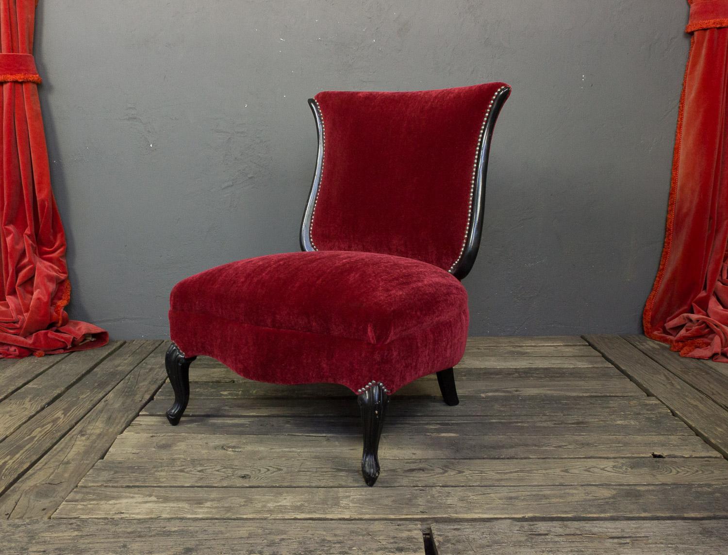 Ein außergewöhnlicher amerikanischer Slipper-Stuhl aus den 1950er Jahren mit kürzlich ebonisierten Beinen. Dieser Pantoffelstuhl ist ein wahrhaft atemberaubendes Möbelstück. Die neue Polsterung aus rotem Samt mit antiken Nickel-Nagelköpfen sorgt für