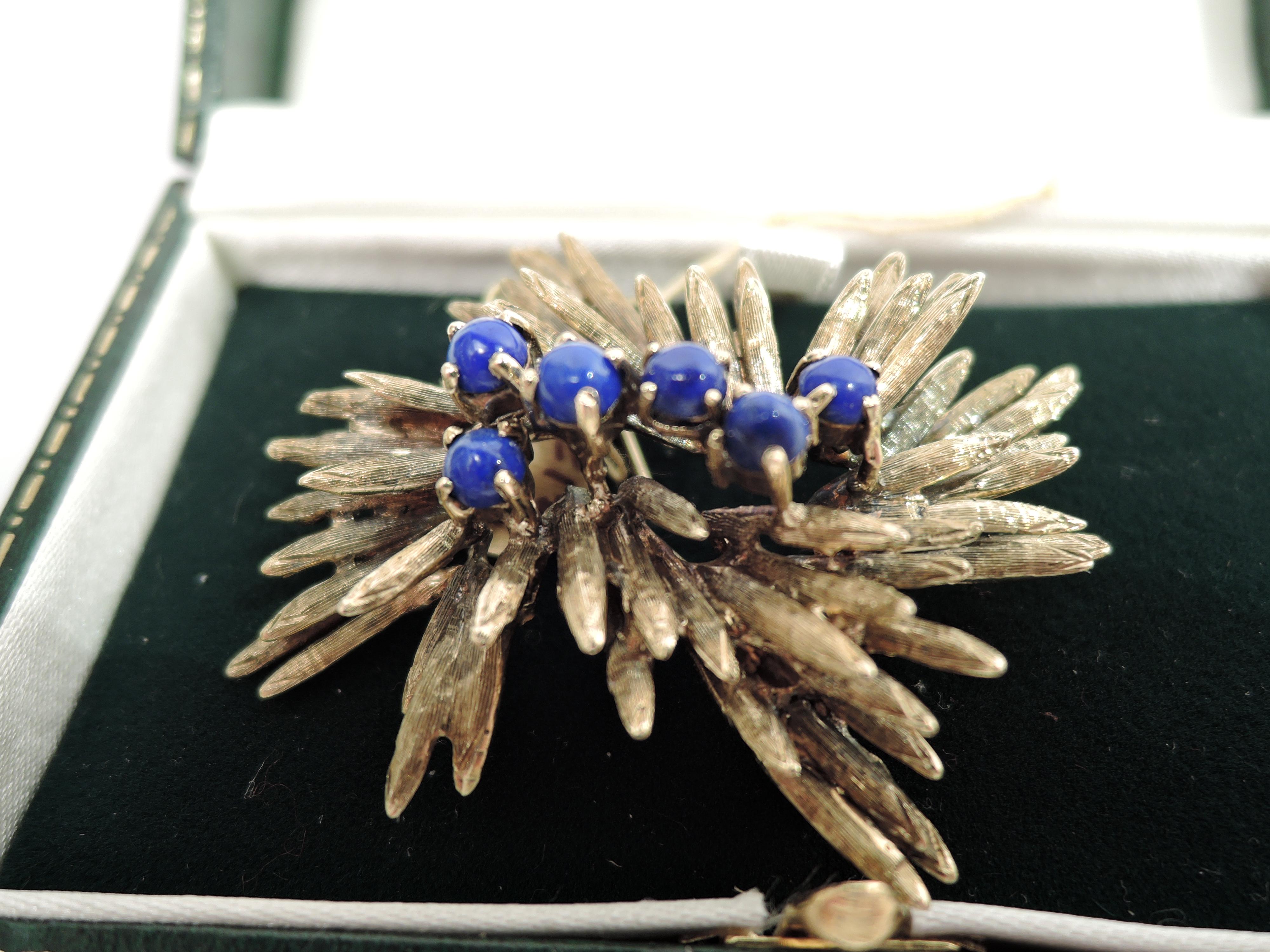 Midcentury Modern brooch. A cluster of lapis lazuli berries mounted to irregular and striated 14k gold leaves. United States, ca 1960s.