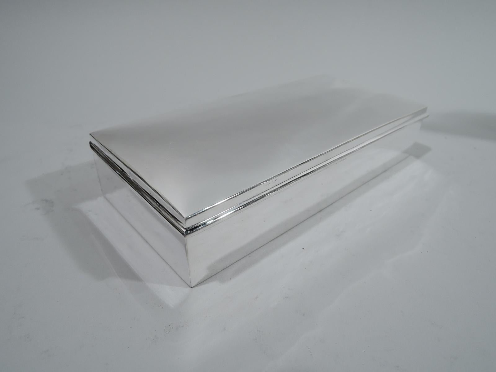 Mid-Century Modern sterling silver box. Rectangular with straight sides and crisp corners. Cover hinged and gently curved with overhanging wraparound rim. Box interior cedar lined and partitioned. Fully marked including no. 455 and stamp for Andrew
