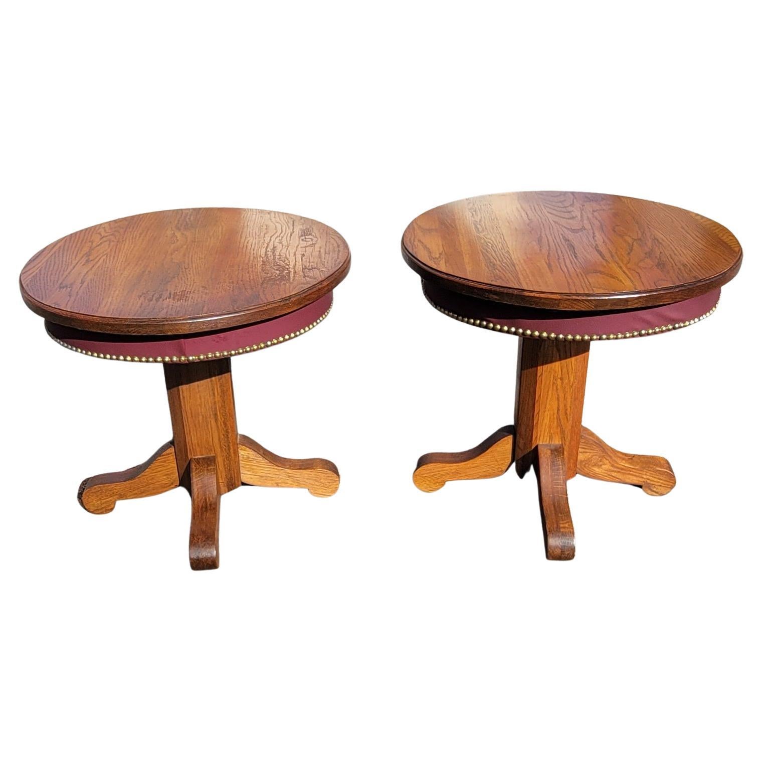 A pair of vintage American Amish mission oak pedestal oval side tables with nail trim over Leatherette apron. Beautifully handcrafted in the USA. Very good vintage condition. Newer leatherette apron with nail trim. Matching cocktail table / coffee