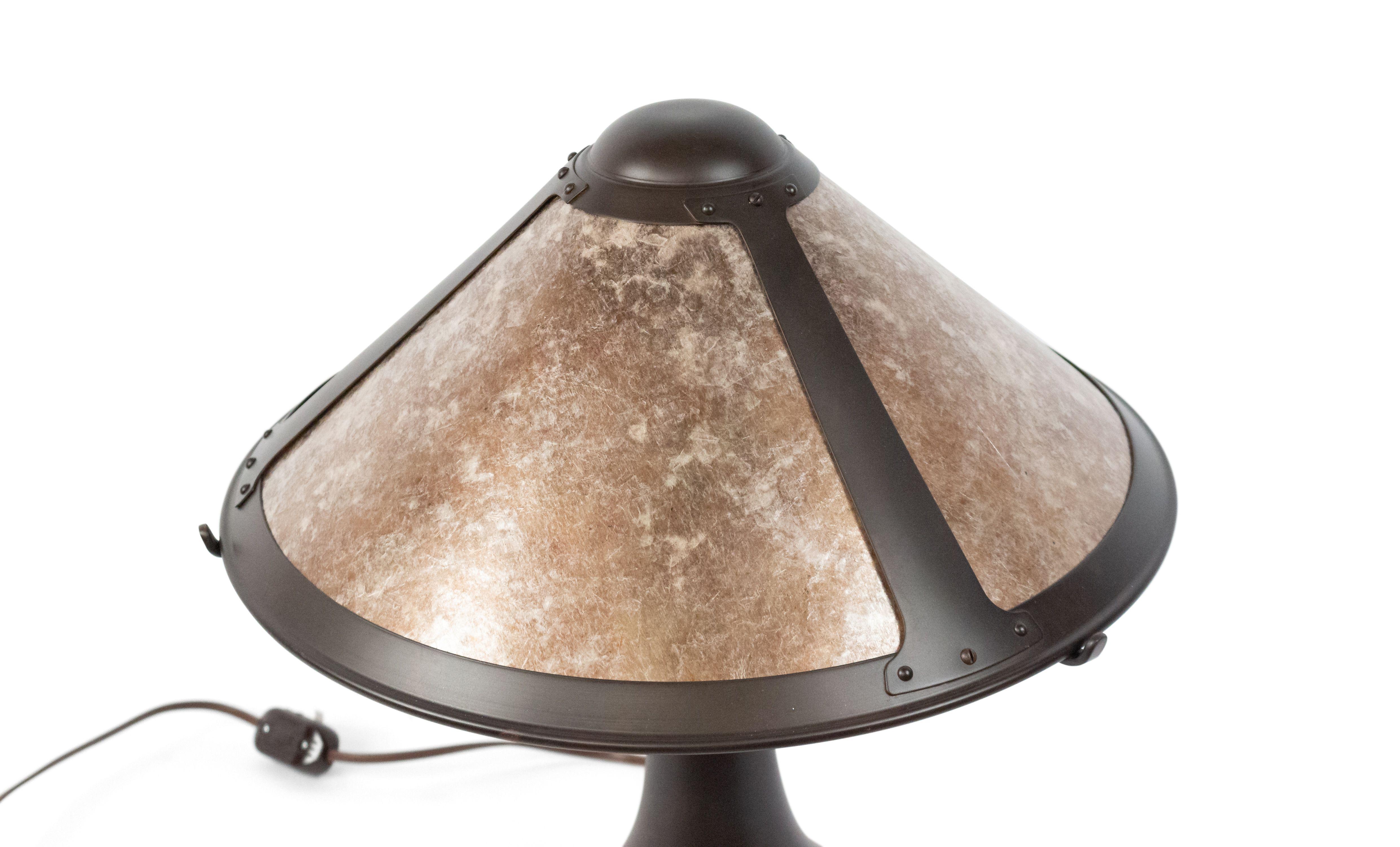 American Mission style table lamp with a 3-panel mica and metal shade supported on a brown patinated tapered base.