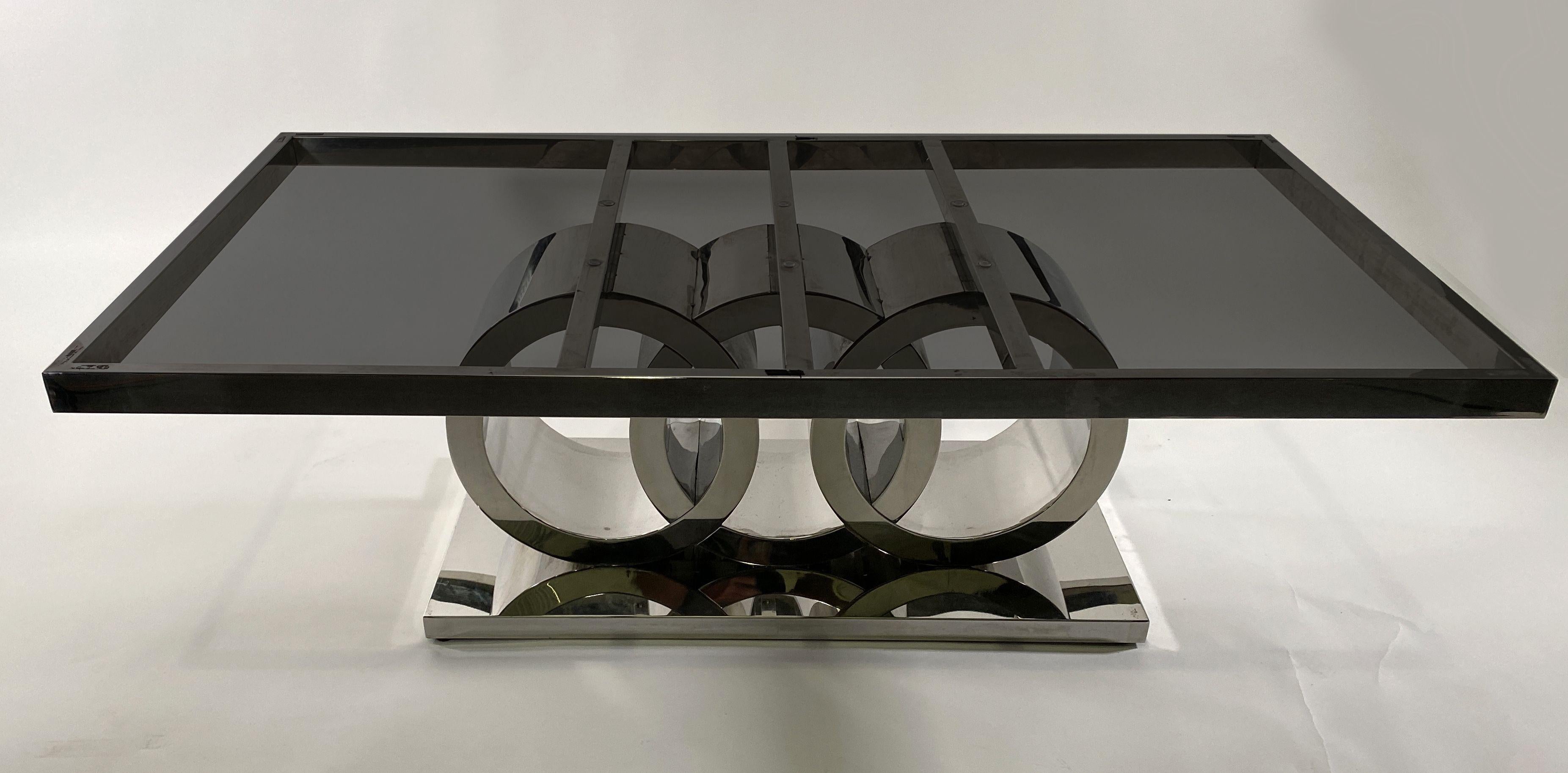 American Modern Art Deco Nickel chrome coffee table by Donald Deskey. The rectangular top being held up by 3 supporting rings on a chrome footed base.