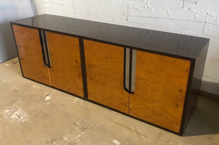 the lacquer body surrounding four burlwood doors, with inset chrome pulls, this credenza is
meant to be wall hung, suspended.