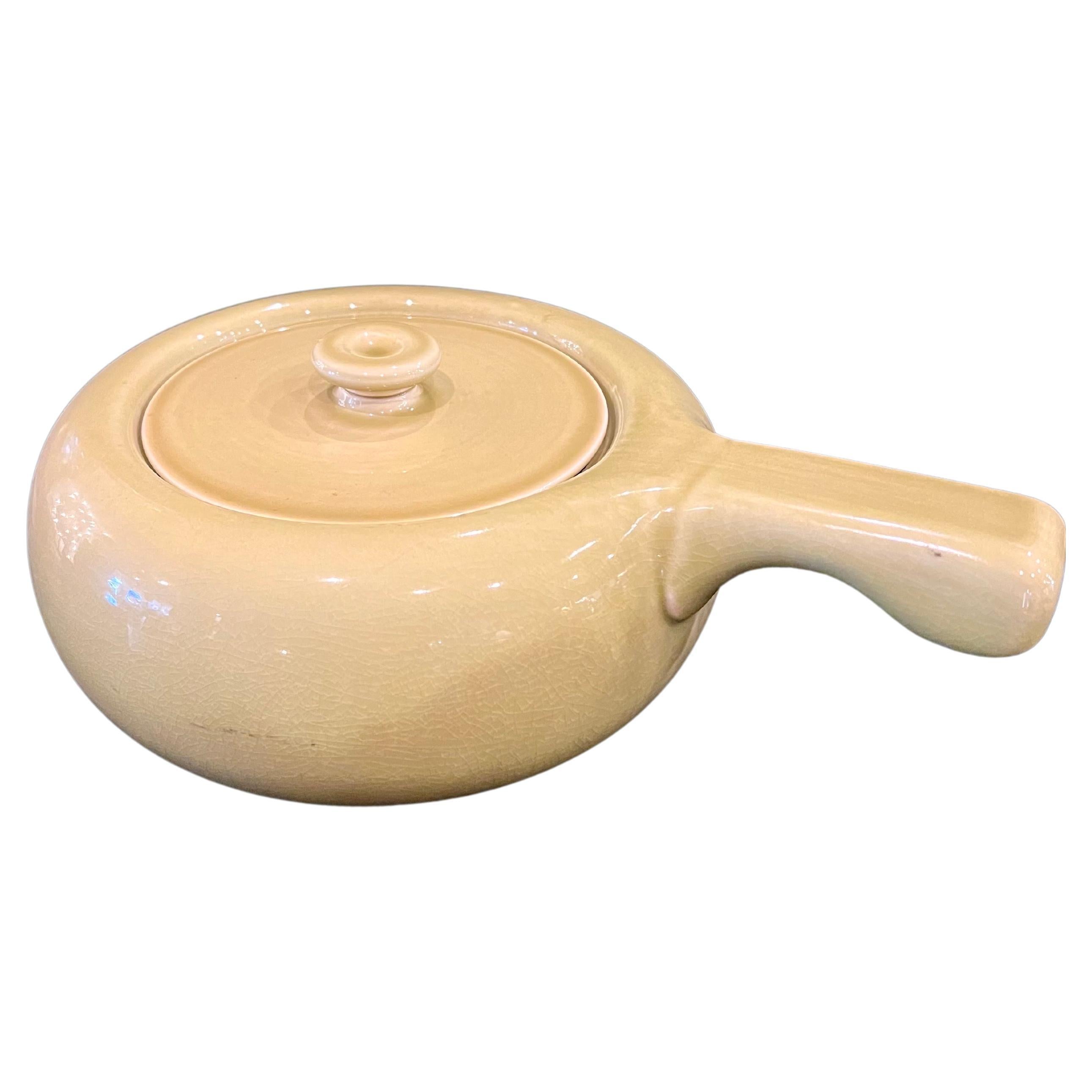 Stylish and functional American modern in chartreuse color handled casserole by Russel Wright for Steubenville pottery of Ohio, circa the 1940s. The ultramodern design emphasizes soft cures and simple glazing. The piece is in excellent vintage