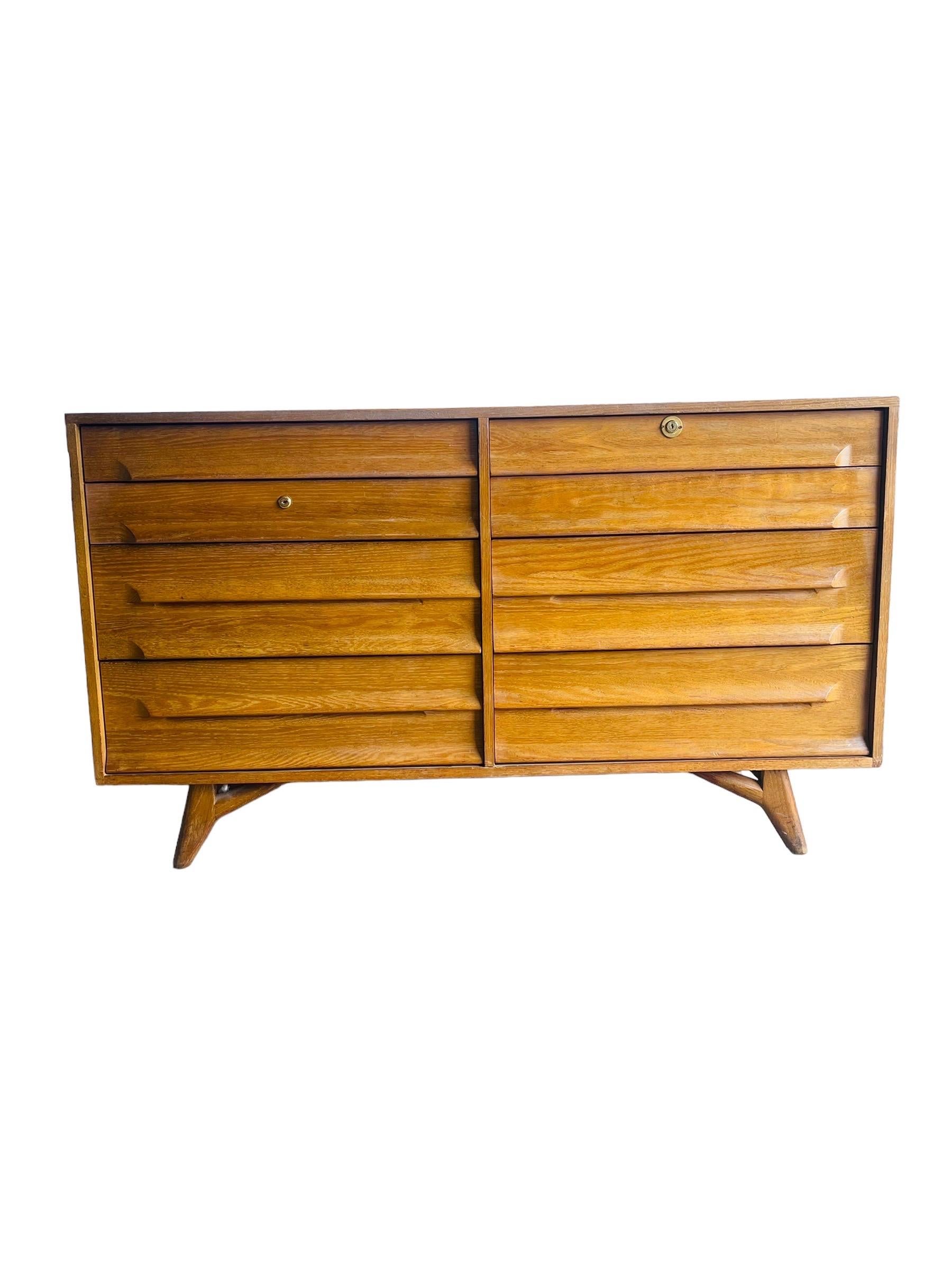 Mid Century American Modern dresser by Jack Van Der Molen for Americana Casual. This solid Oak dresser is equipped with eight drawers and sculptured legs. This dresser is in good original vintage condition with wear consistent with age and use.