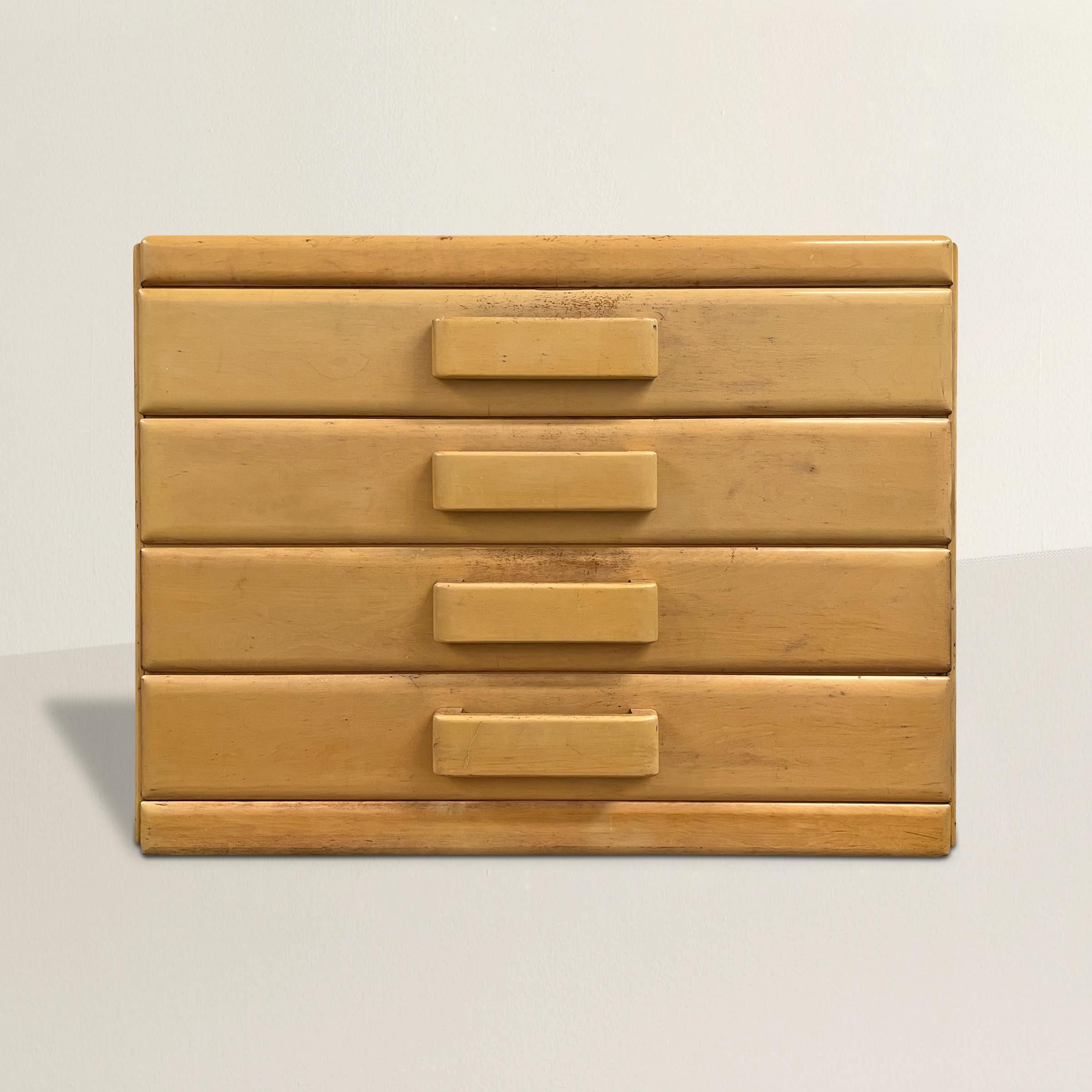 Eine schicke Kommode im amerikanischen Modernismus des frühen 20. Jahrhunderts mit vier Schubladen mit breiten Holzgriffen und einer schönen, zeitlosen elfenbeinfarbenen Lackierung, die sich nahtlos in zahlreiche Designstile einfügt. Ideal für Ihr