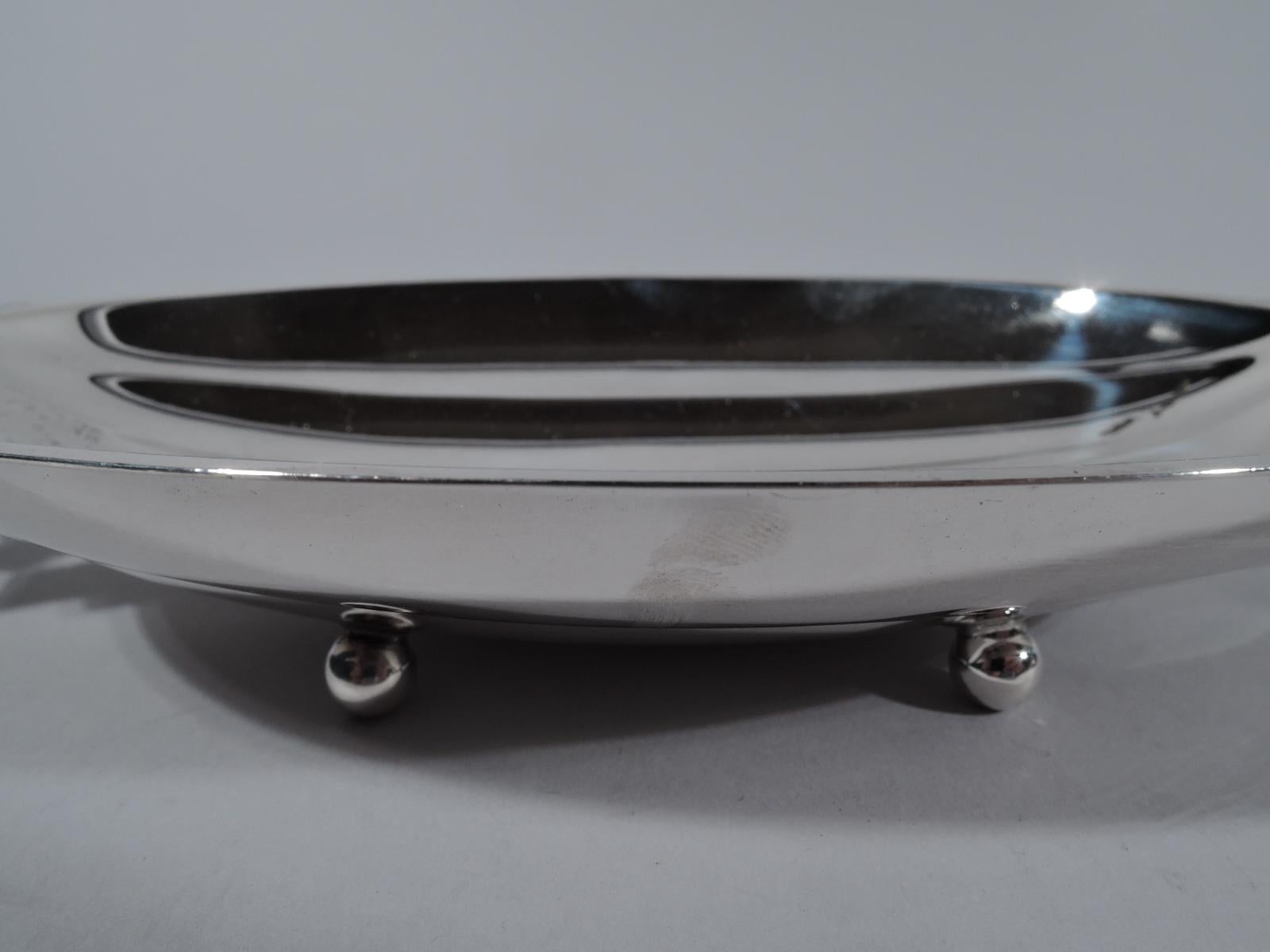 Modern Classic sterling silver melon bowl. Made by Tiffany in New York, circa 1941 Shallow and fluted oval bowl. End handles pierced with stylized leaves and scrolled vines. Rests on 4 ball feet. Fully marked including pattern no. 22974 (first
