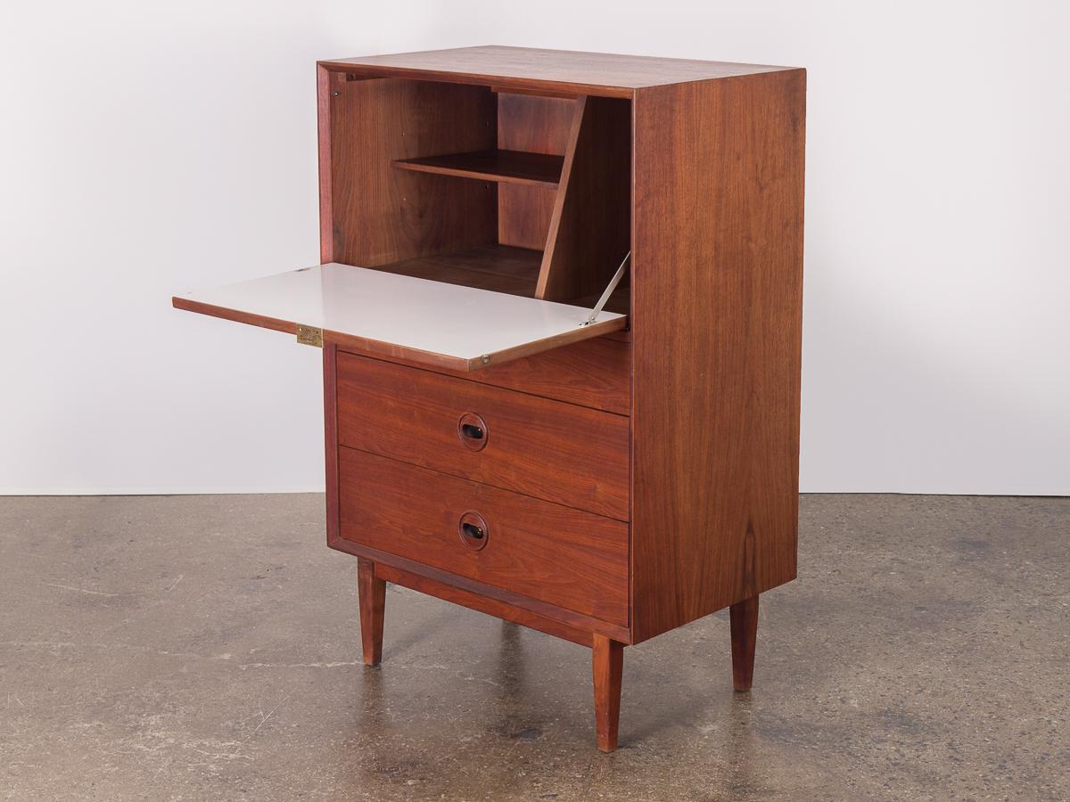American modern walnut secretary. Sturdy, substantial secretary features a pull-out desk with adjustable interior shelves. Three drawers below allow for extra storage and are adorned with lovely carved circular pulls. Tapered legs elevate the body