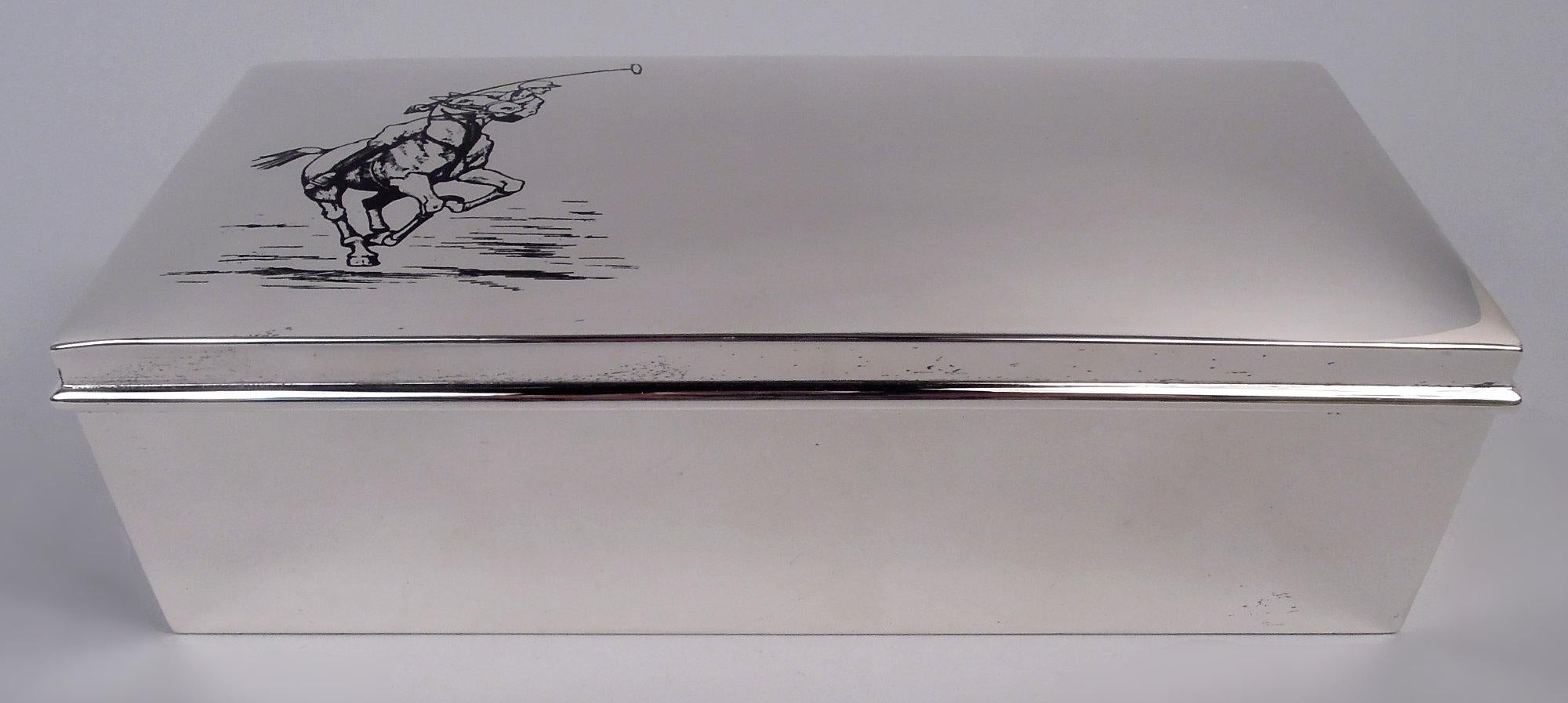 Scatola moderna in sterling, 1920 circa. Rettangolare con lati diritti. Coperchio incernierato con bordo sporgente e parte superiore curva; in smalto nero, un giocatore di polo su un pony in carica con una mazza sollevata. Foderato di cedro.