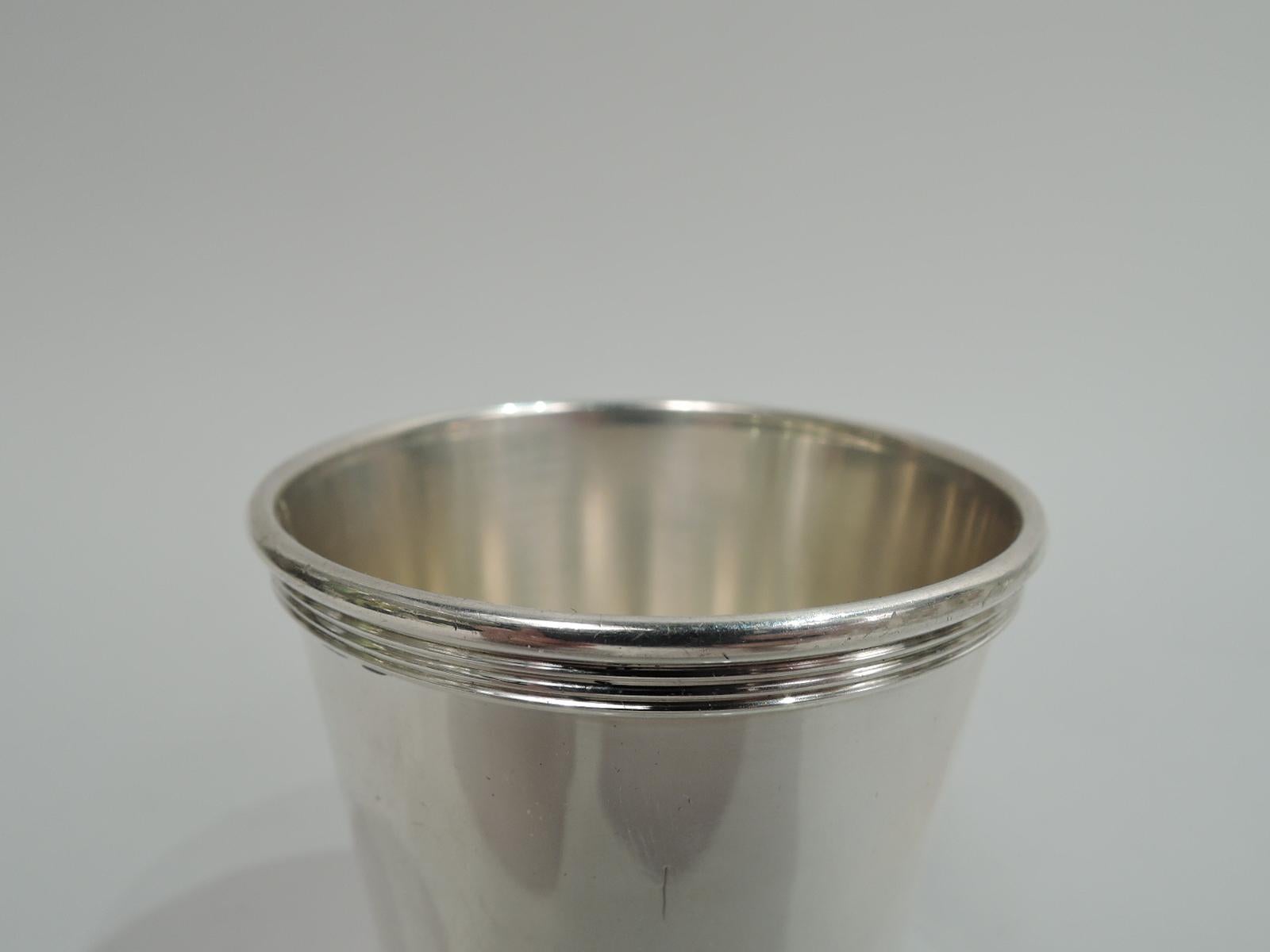 Modern sterling silver shot glass. Made by Manchester in Providence. Straight and tapering sides, and reeded rim and base. On underside is engraved presentation: “For / 19 years loyal service / with / Brown-Forman / 1965”. Fully marked including