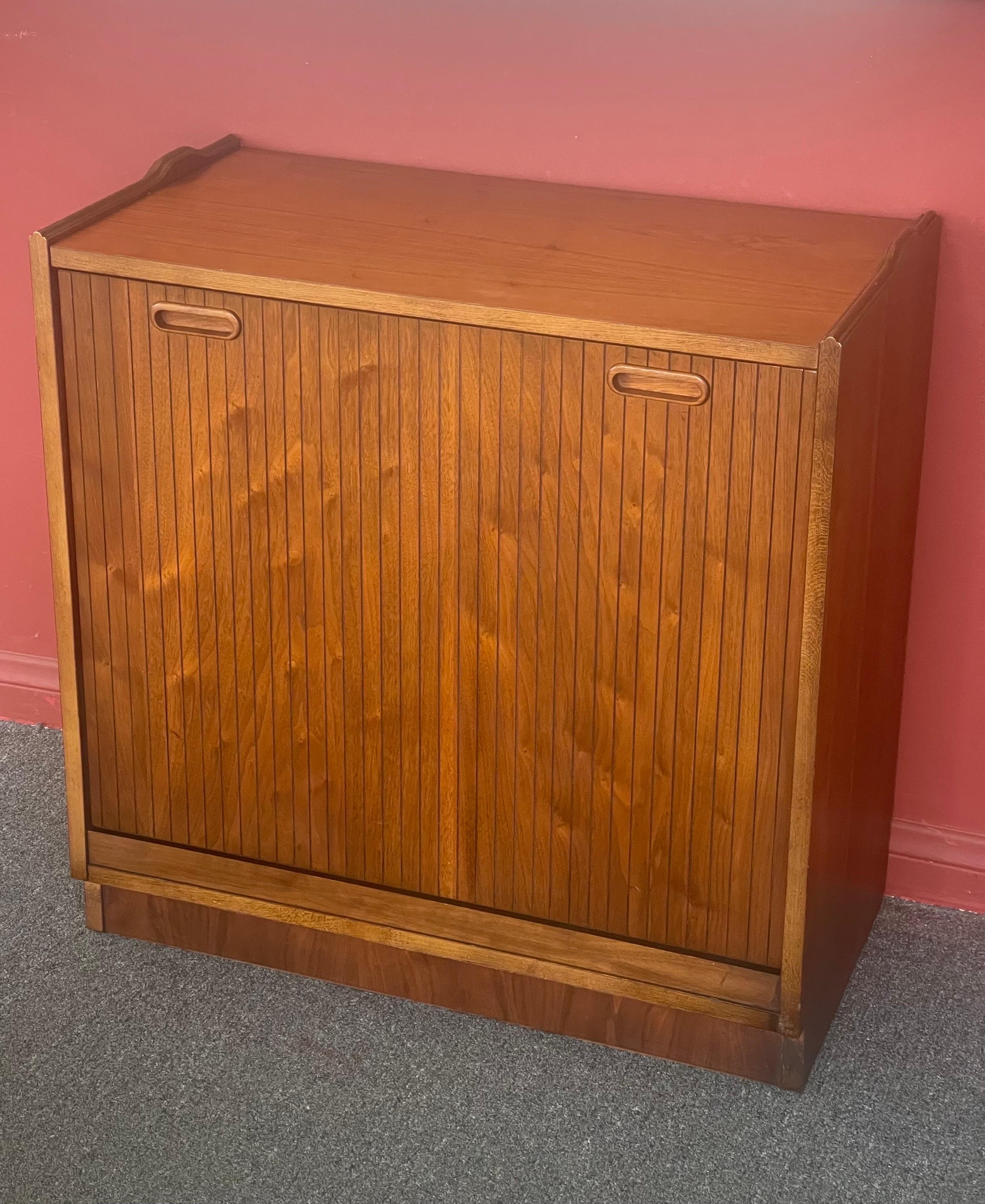 A very clean American modern walnut record cabinet with pull out door / drawer by Lane Furniture, circa 1970s. The cabinet is designed to hold over 125 12