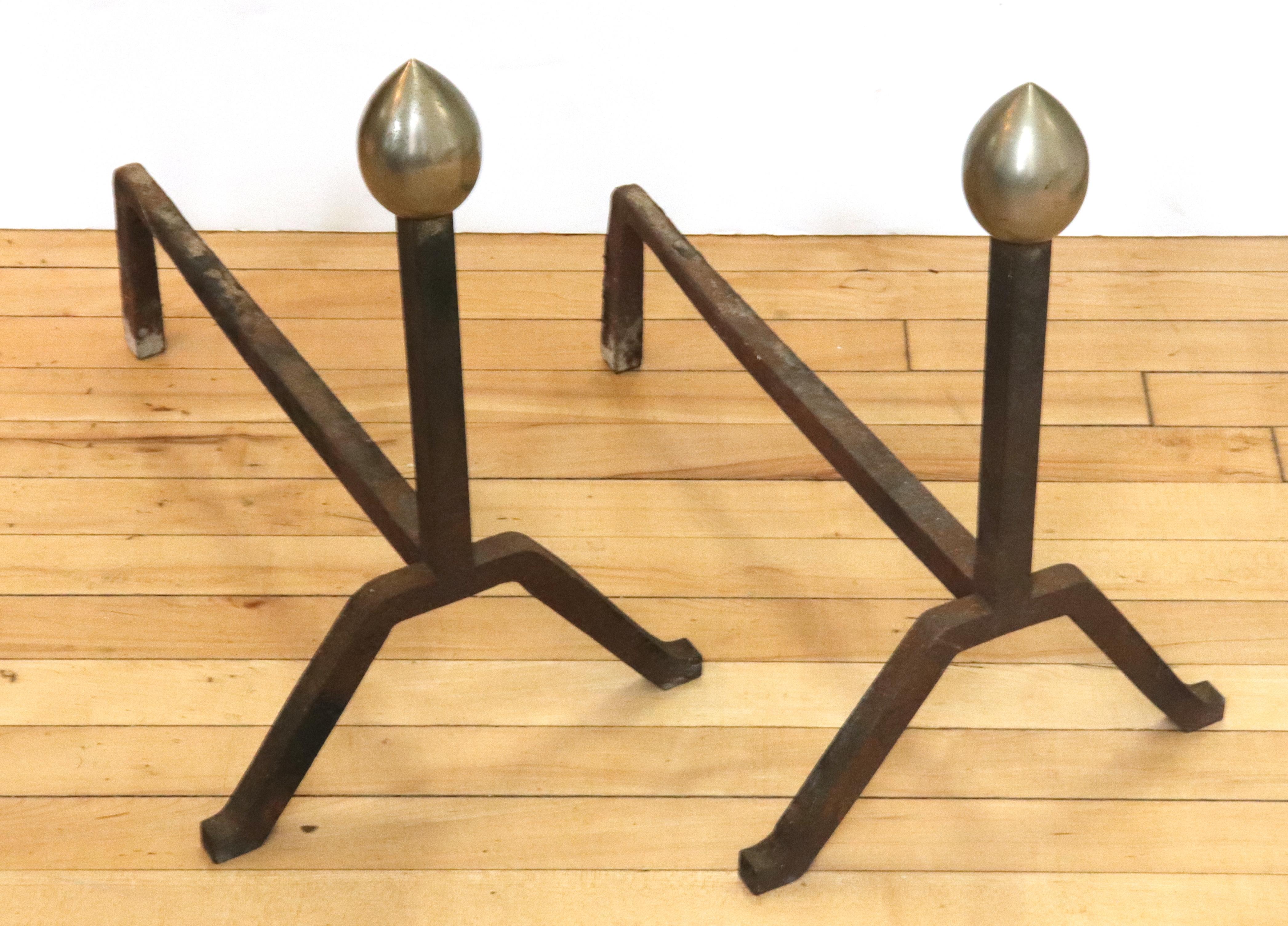 American Modernist pair of andirons made in steel and iron. The pair was made during the circa 1930s-1940s in the United States and has decorative pine cone finials. In great vintage condition with age-appropriate wear and use.
