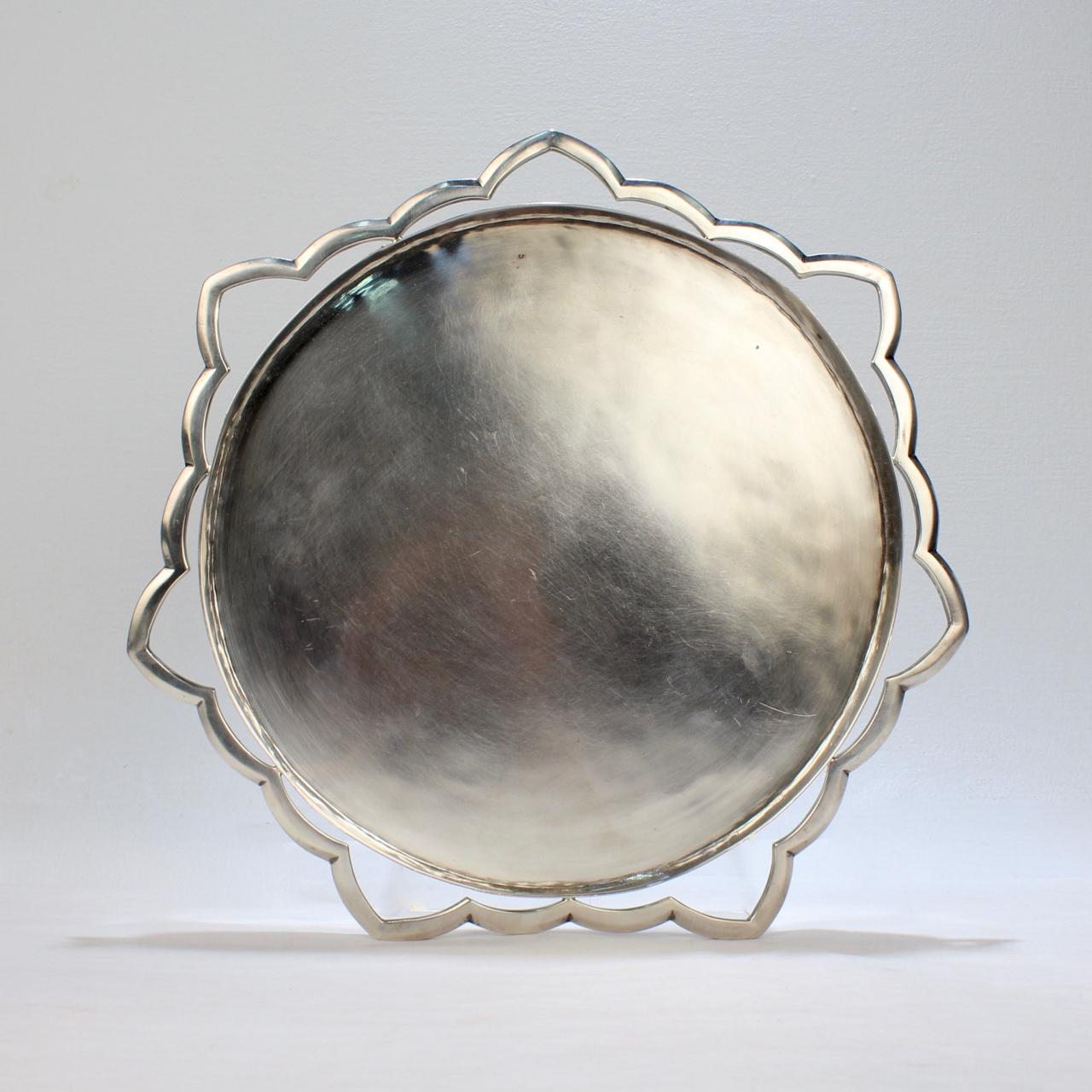 A fantastic Modernist sterling silver tray by Henry Petzal.

Around the circumference of the round, shallow tray is an openwork starburst border.   

Harry Petzal was an important German born, Modernist American silversmith, whose work was widely