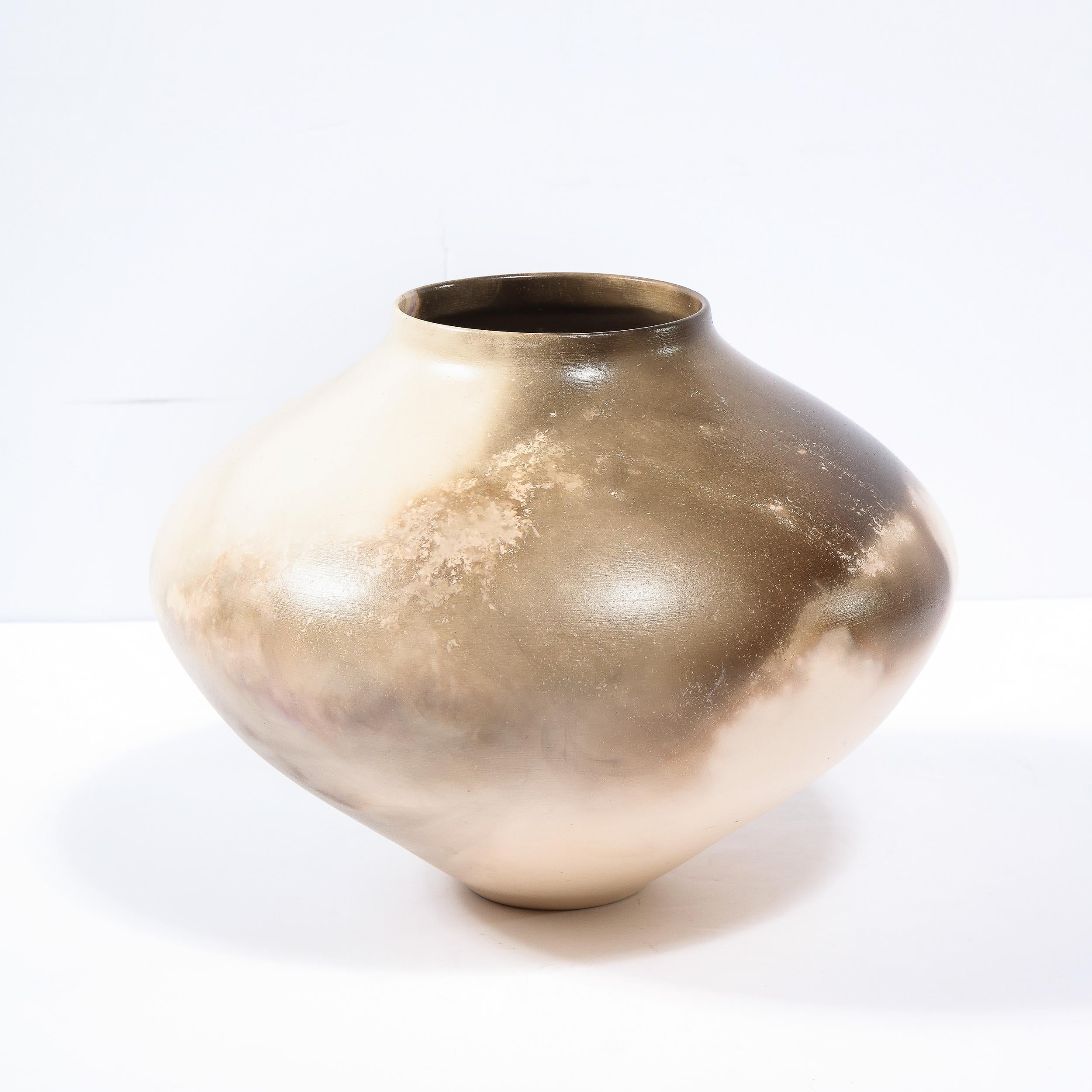 This elegant modernist vase was realized in the United States circa 1980. It features a conical form that flares dramatically at its shoulders before tapering to an economical circular mouth. The exterior of the piece has been hand glazed in java