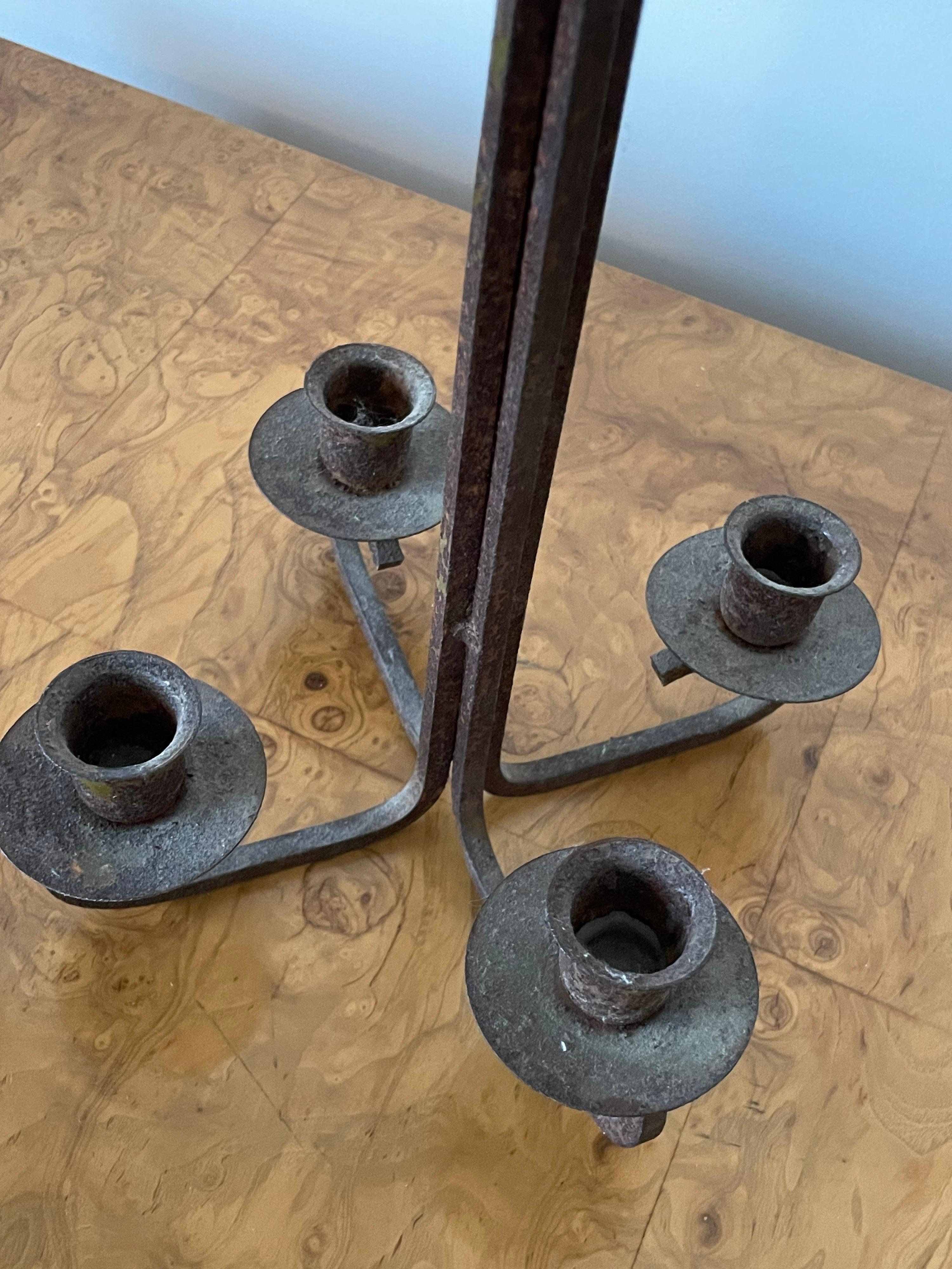 Unusual modernist candelabra which can be used table top or hung. Heavily patinated wrought iron. Four candlestick holders.