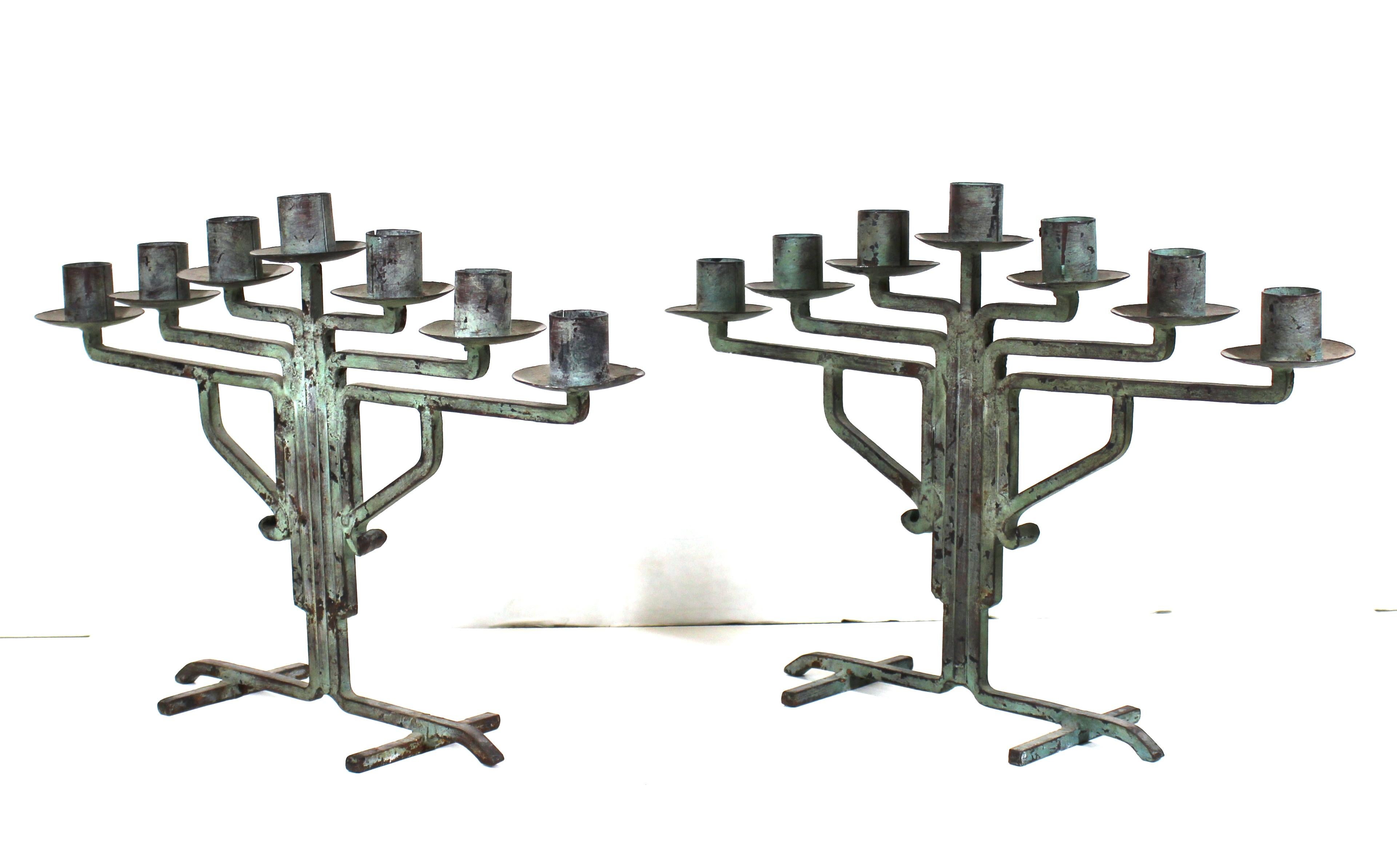 American modernist pair of candelabra with green patina, designed in the pioneering Prairie School style that was developing in the U.S. during the early 20th century. The pair is made of wrought iron and bronze and was likely manufactured in the