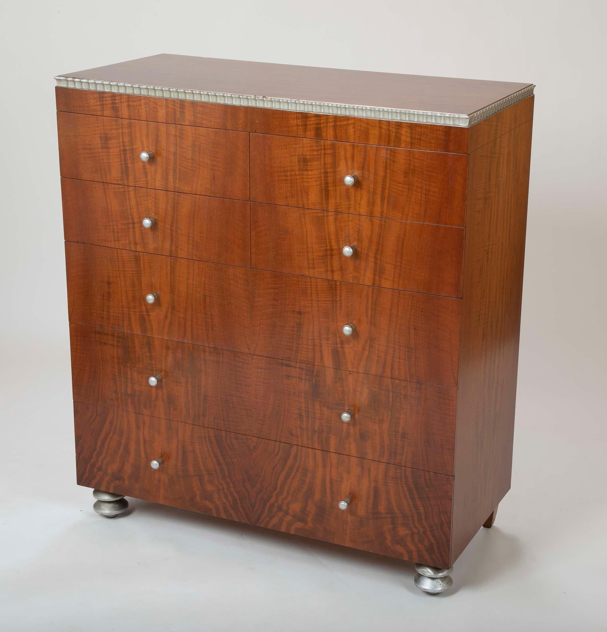 A handsome American Modernist tall chest of drawers. With beautiful flame walnut veneer and silver painted highlights, the epitome of modern design.
Retailed by Paine Furniture Company of Boston. We also have a single bed from the same
