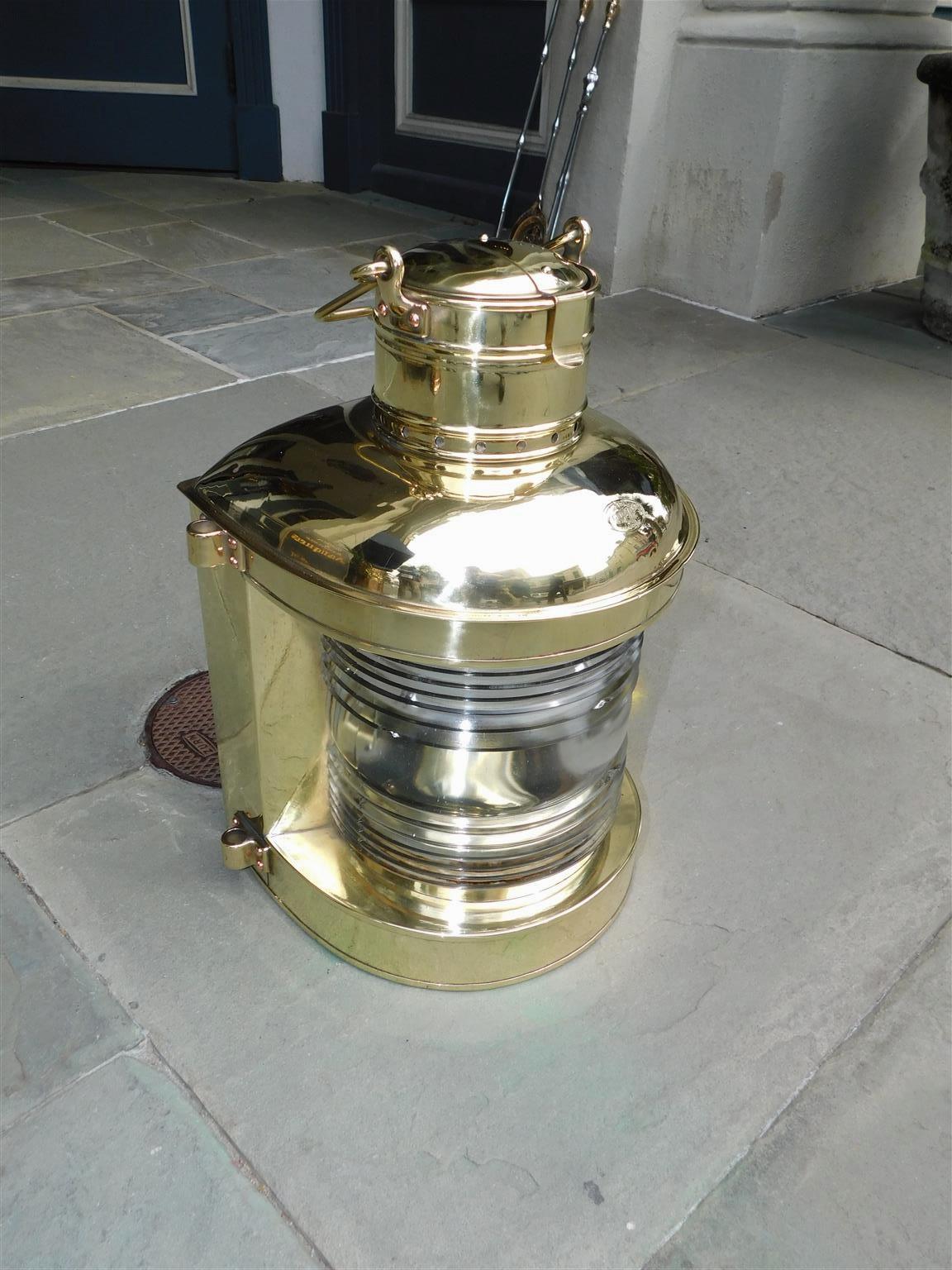 American Nautical brass Perko marine lantern with the original Fresnel lense, exterior side mounts, vents, and locking interior oil font. Stamped Perko Brooklyn, New York. Early 20th Century.
 