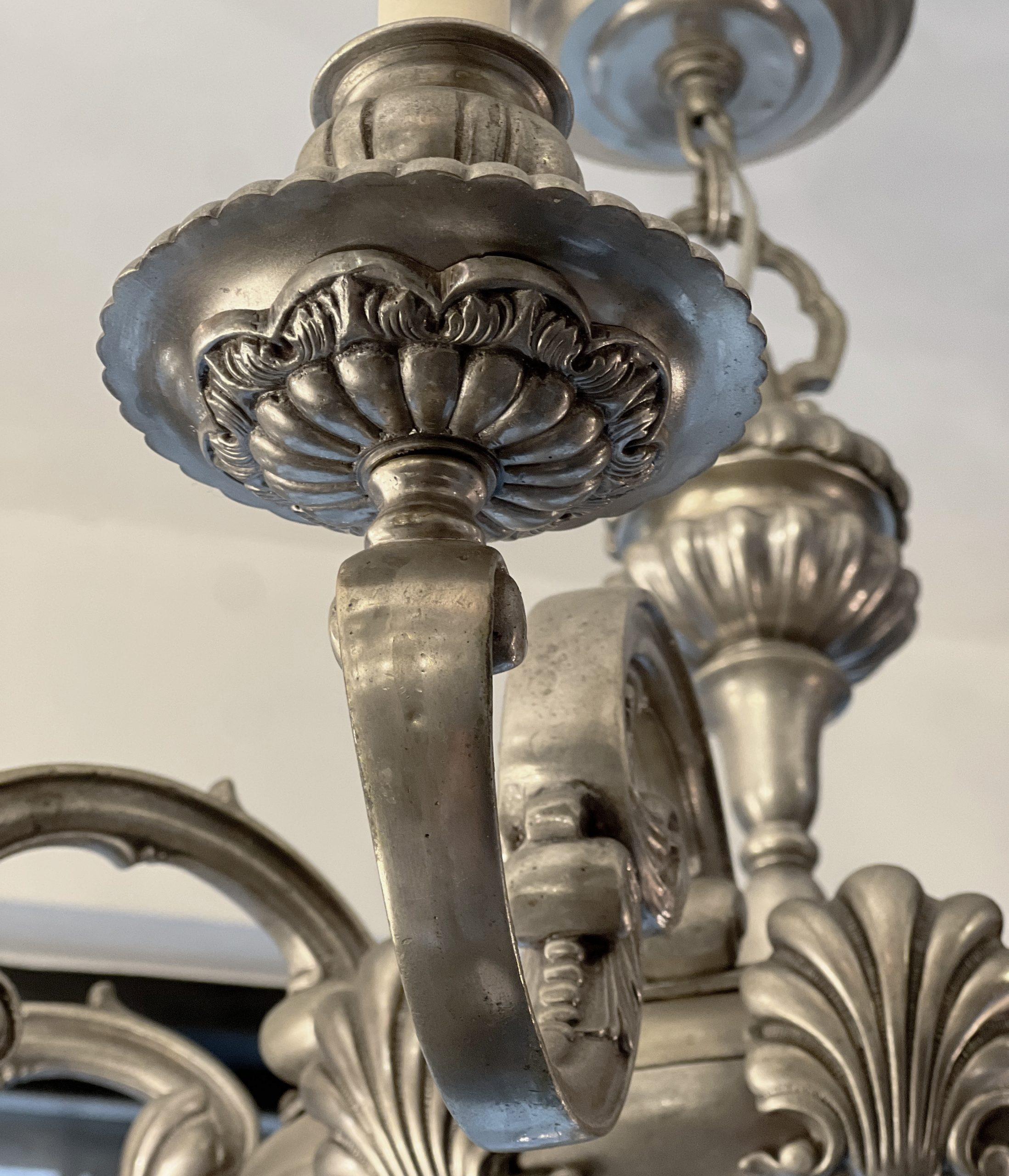 A circa 1910's American silver-plated neoclassic style 10-arm chandelier with shell motif.

Measurements:
Height: 26