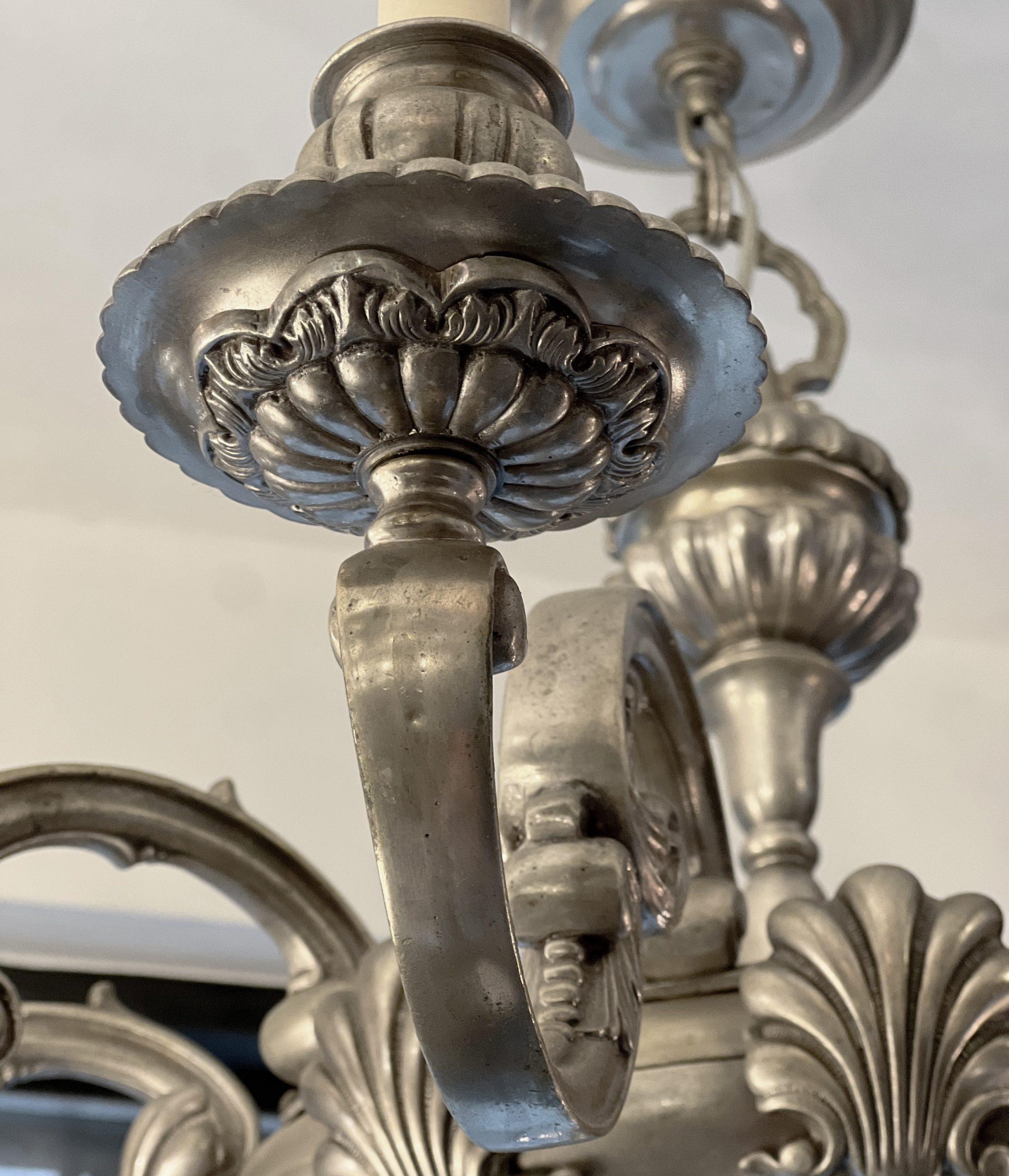 Lampadario a 10 bracci in stile neoclassico placcato in argento del 1910 circa con motivo a conchiglia.

Misure:
Altezza: 26