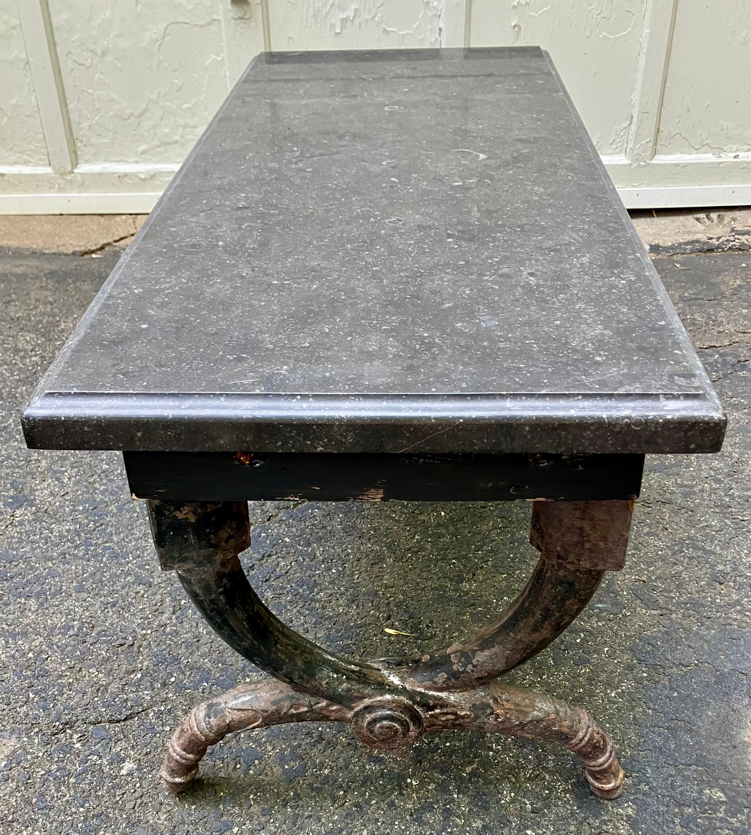 American Neoclassical Iron and Marble Bench.  Antique and rare American Greek Revival Neoclassical bench with cerule form legs with Greek key blocking in cast iron with supporting Belgian black ogee edged marble top for use as coffee table or bath /