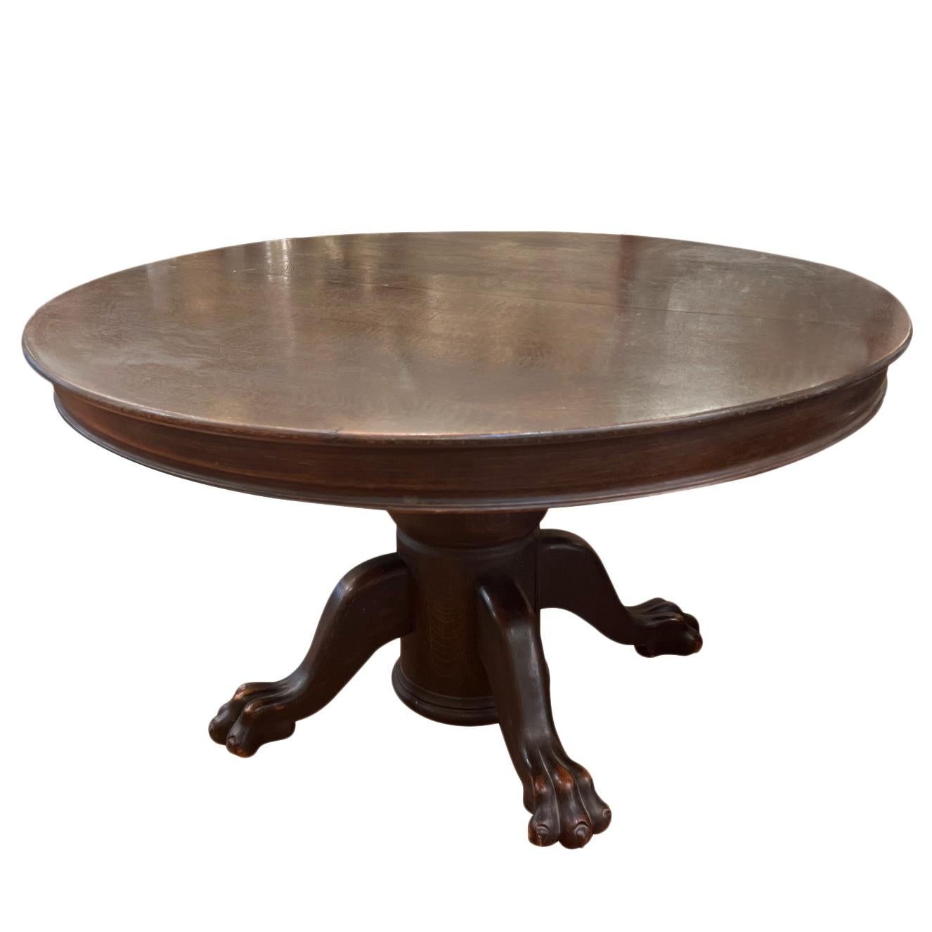 Late 19th century American carved oak dining table with extensions leaves and with lion's paws feet.

Measurements:
Height 30