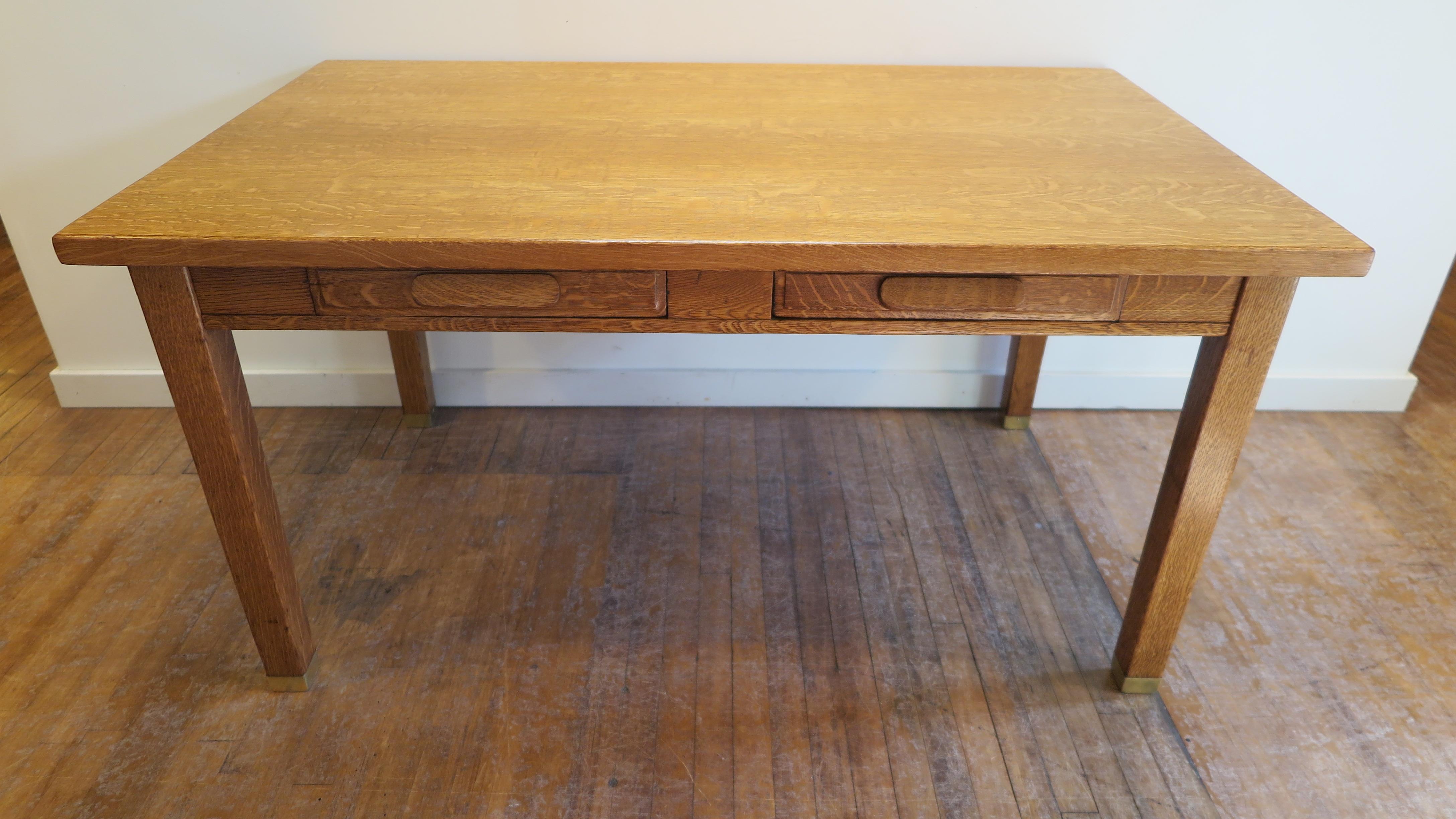 Oak library desk, American, 1920-1940. Quarter sawn oak top, sold oak body with two full length drawers having tapered legs with brass feet caps. The brass sabot caps add a subtle sophistication to the clean lines of the desk presenting it