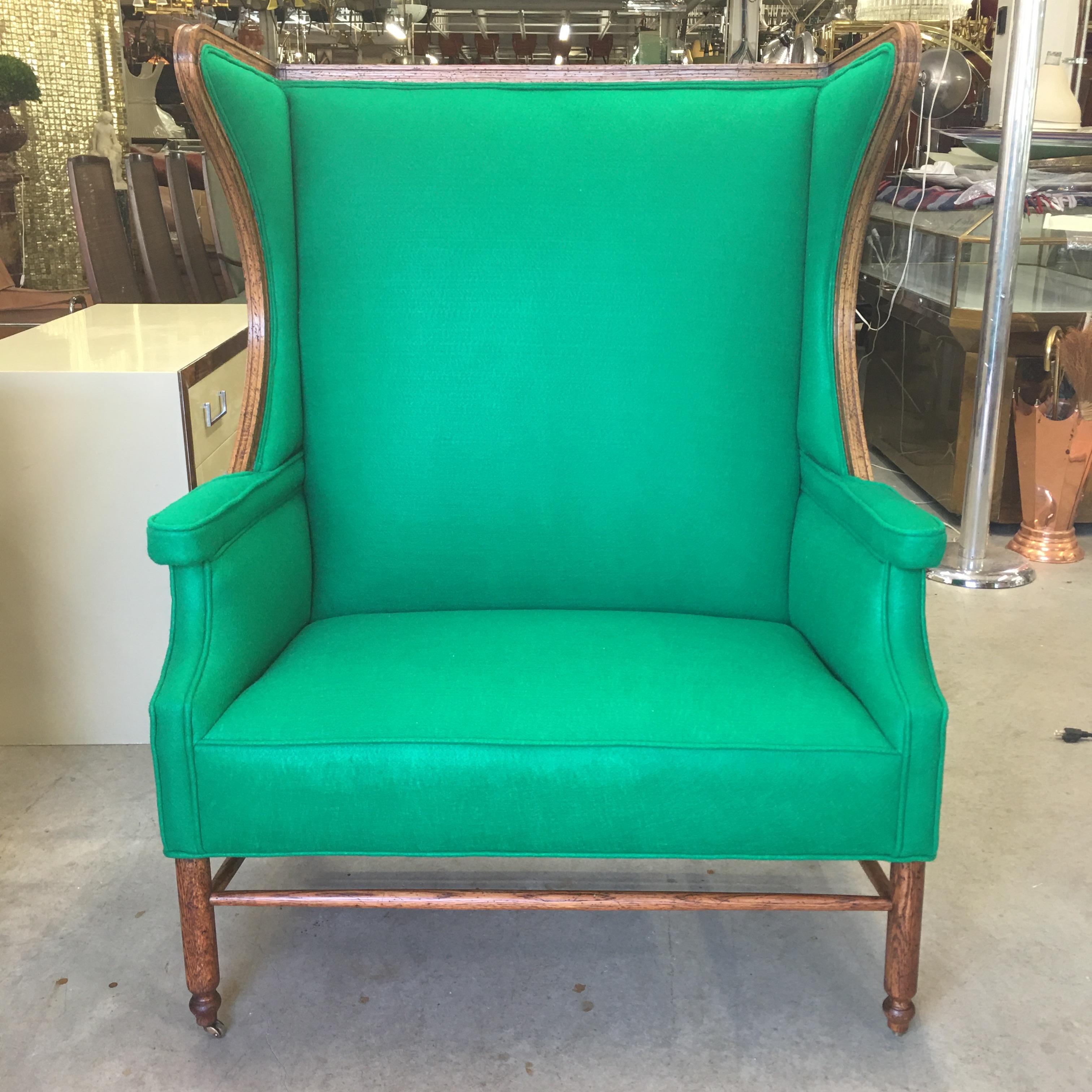 American oak wing back settee bergère of unusual form and extra wide, tapered stretchers, straight round legs on brass casters, newly restored and reupholstered in emerald green wool felt.  In the style of Kaare Klint for Rud Rasmussen (see last