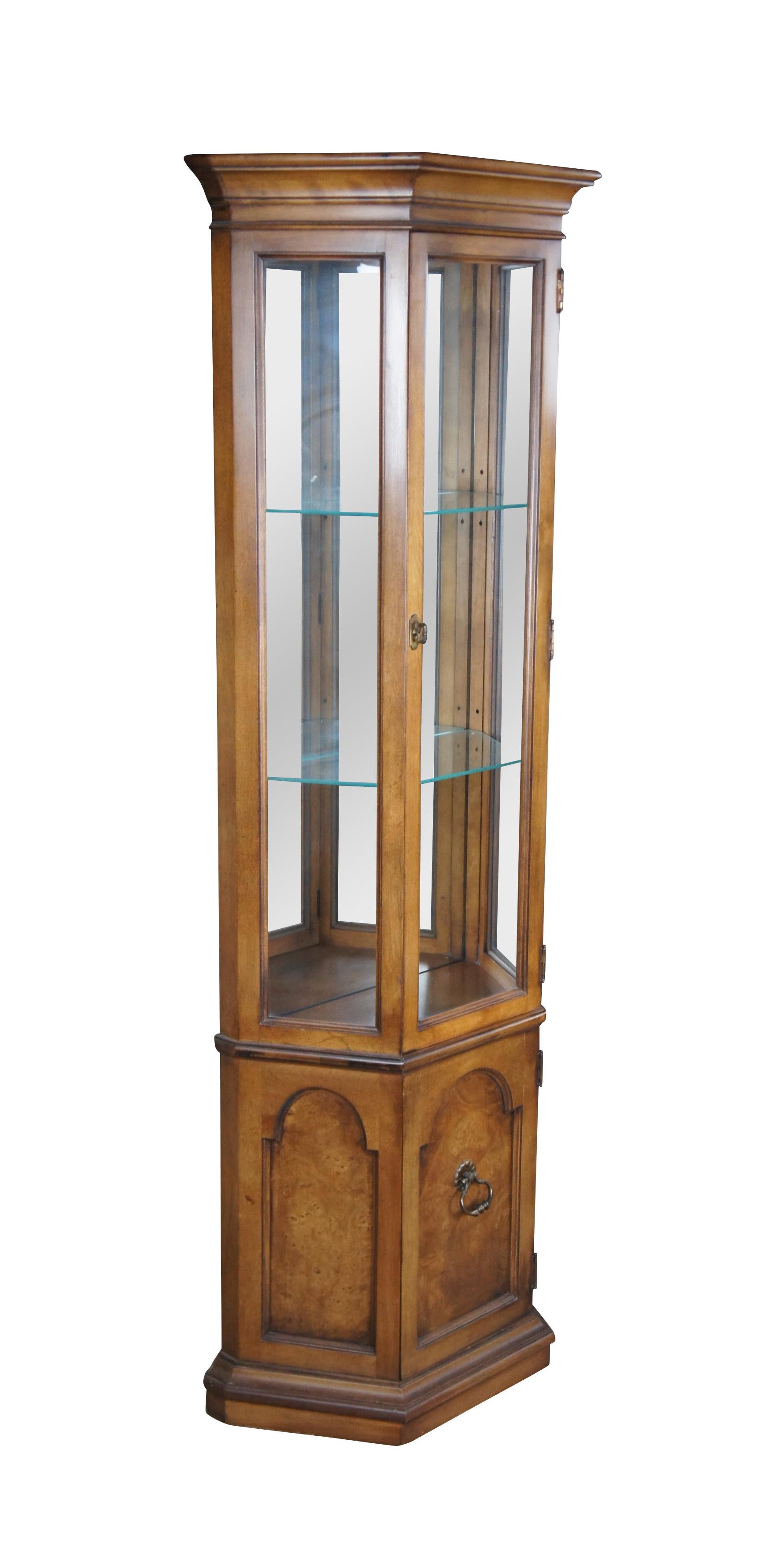 Vintage American of Chicago curio cabinet or display case.  Made of walnut featuring a three sided half hexagon design with paneled cabinet base supporting a tall curio cabinet with adjustable tiered shelving.

Dimensions:
24.5