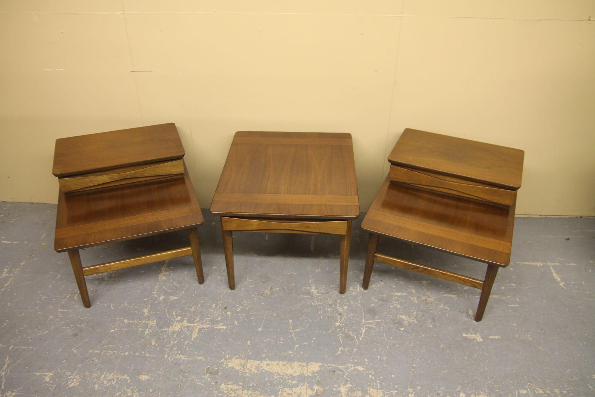 Great 3 piece table set from American of Martinsville. I have not seen this design come to market yet. These table are made of walnut and have the unique bowtie draw fronts on them. 
Single side table/coffee table is 22.5 x 27 x 19.25
Two end