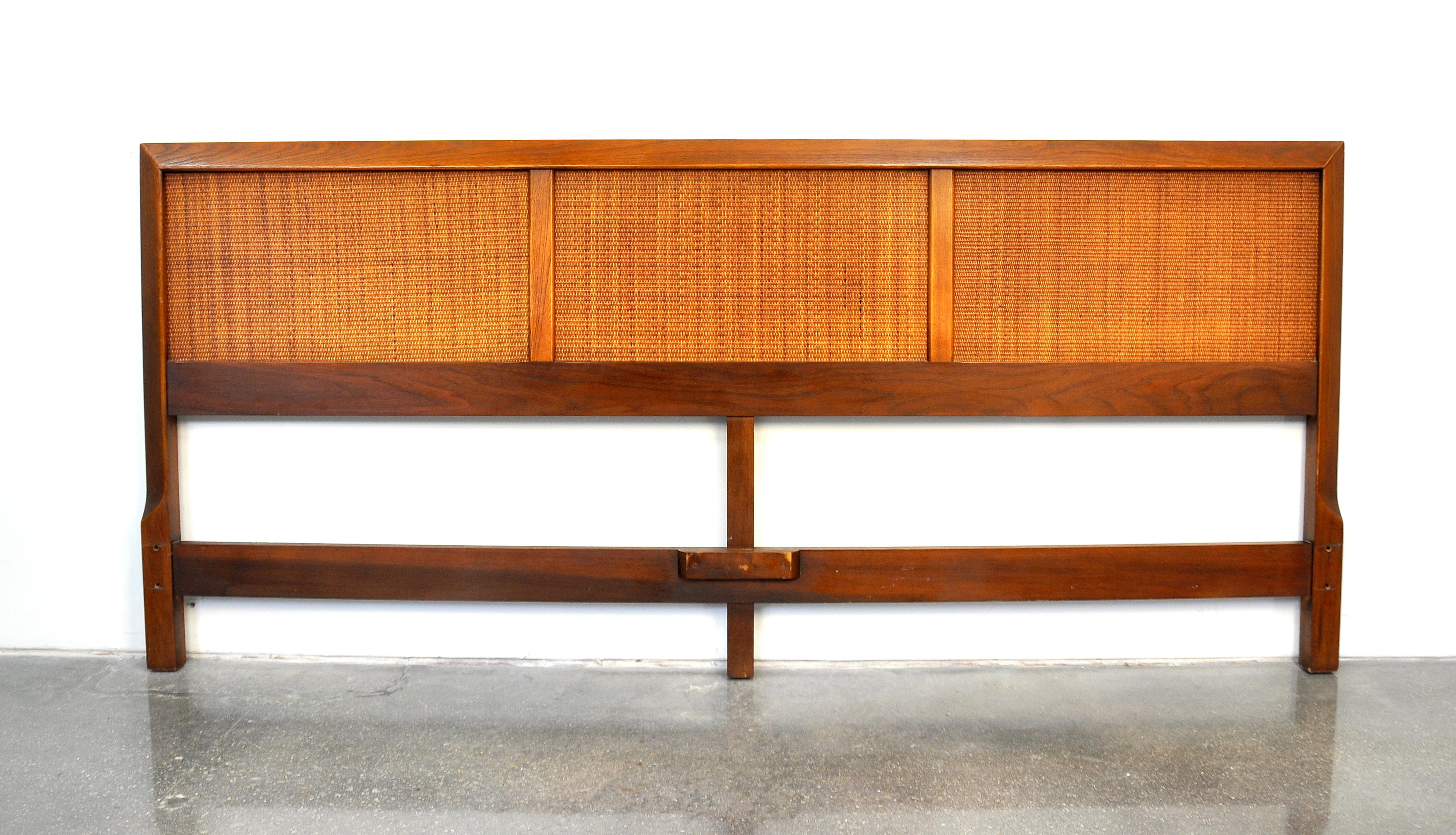 A vintage Mid-Century Modern king-size walnut headboard from the desirable Accord line manufactured by American of Martinsville in the 1960s. The bed features caned panels and a solid walnut frame.