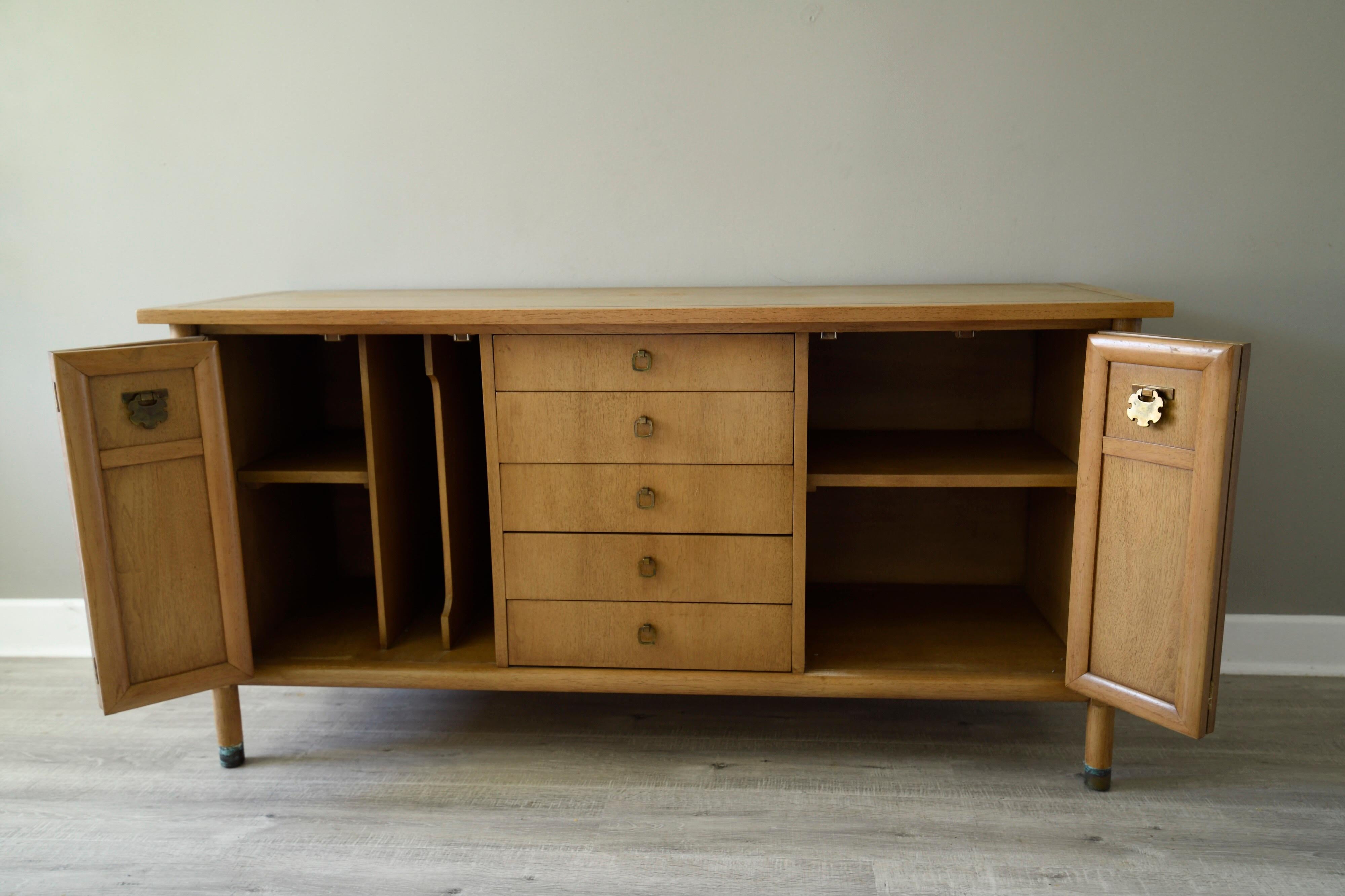 A rarely seen buffet, credenza or sideboard designed by Merton Gershun for American of Martinsville, this chinoiserie credenza features five-drawers in the middle and compartments on either side with shelving. It has gorgeous brass details and