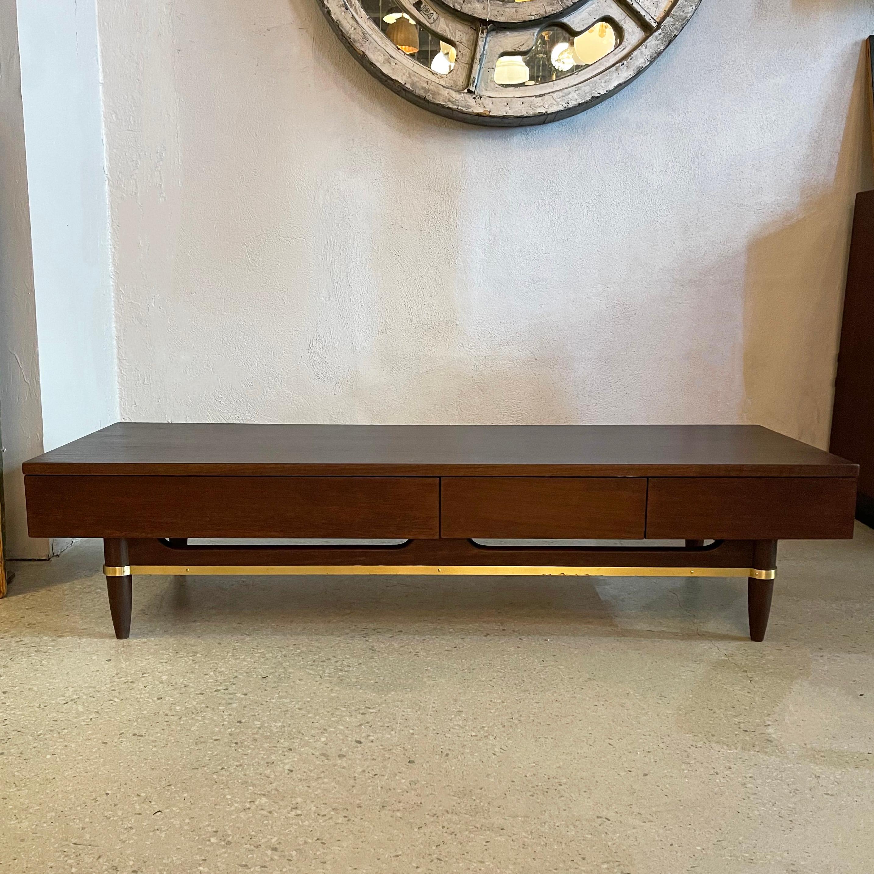 This versatile, multi-purpose, ebonized walnut and brass piece designed by Merton Gershon for American Of Martinsville works in many capacities. It is finished on 3 sides to go up against a wall which makes it perfect as a low console, media cabinet